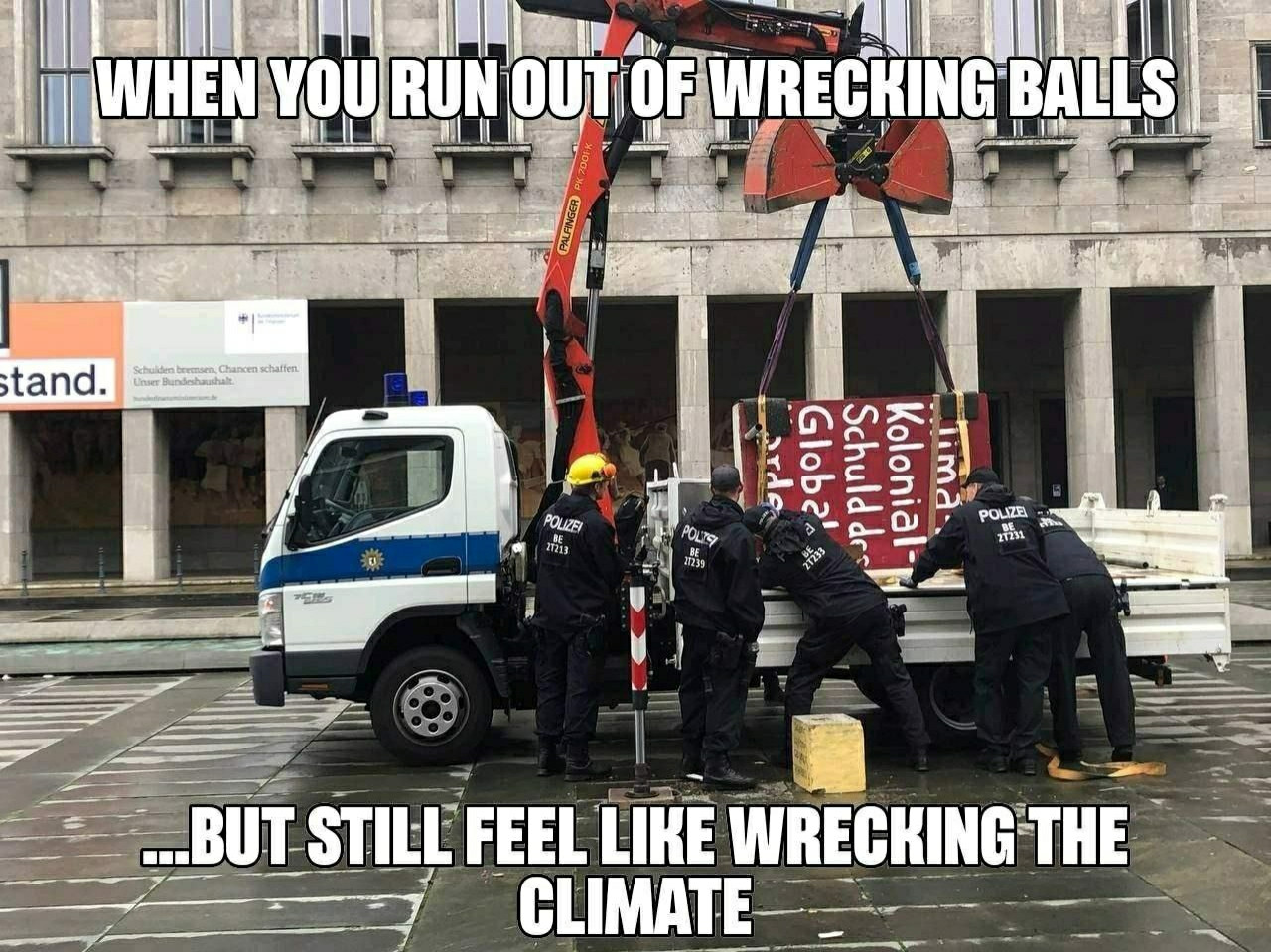 A police truck lifting the concrete block. Police people securing the truck and their loot.
Text: when you run out of wrecking balls ... But still feel like wrecking the climate