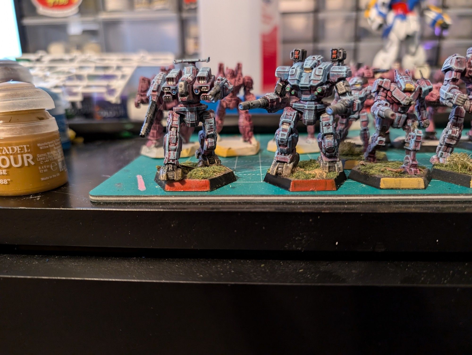 two painted Battlemechs, a Rifleman RFL-3N and a Warhammer WHM-7D from Battletech in a blue paint scheme with a light purple undercoat and a number of silver and metallic details picked out, with the front hex of the base painted metallic red