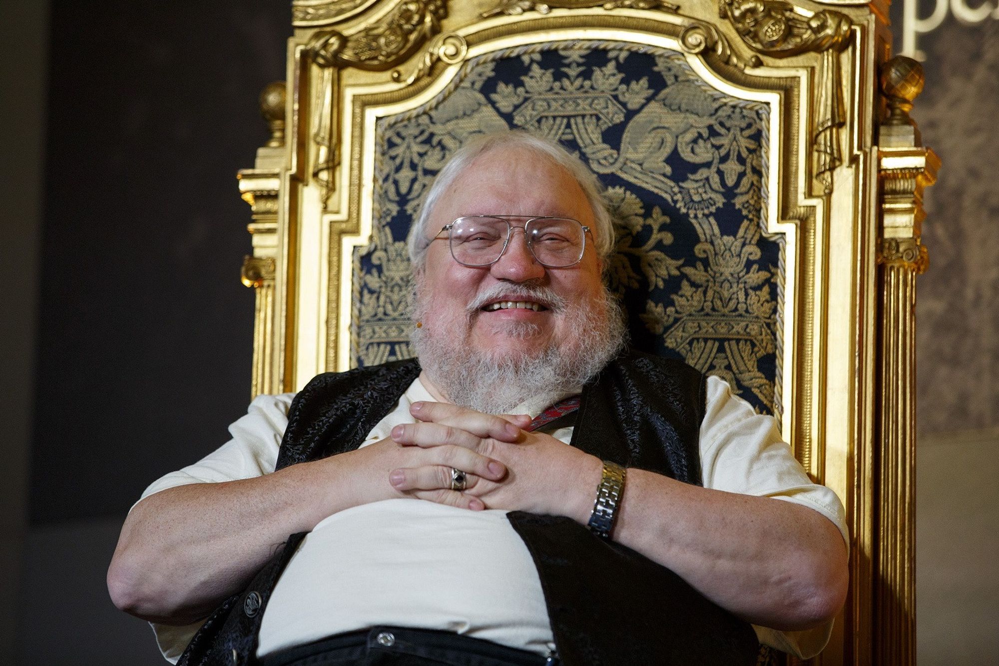 Photograph of multi millionaire George R.R. Martin, perched upon his golden throne.