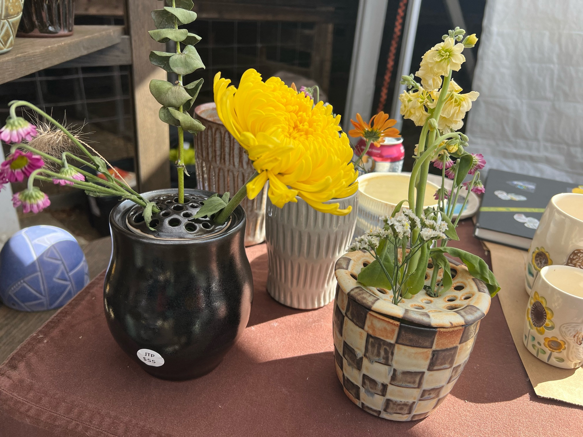 Photo of clay pots with pretty yellow and pink flowers in them.