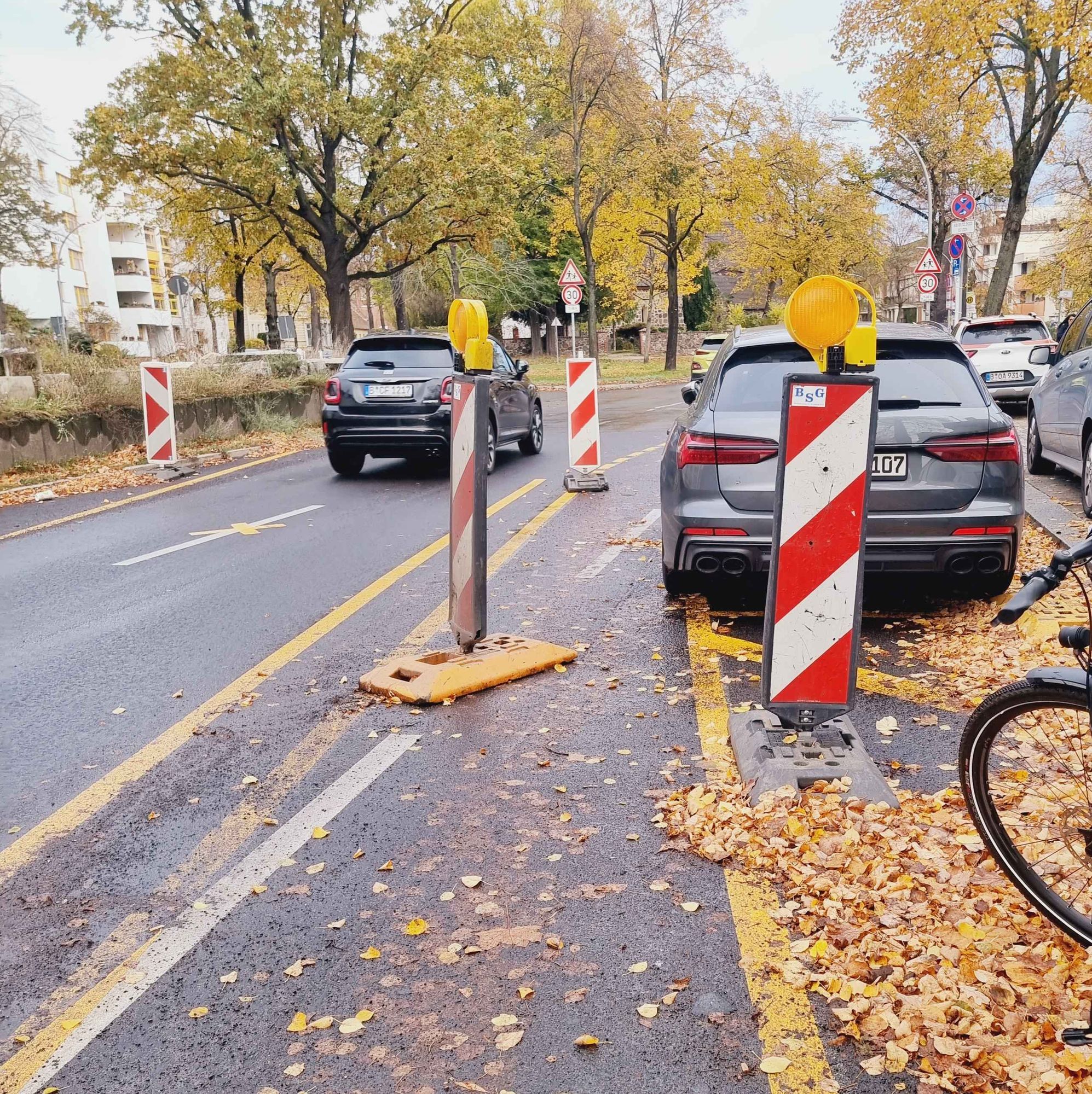 Baustellenführung Radweg.
Auf dem Radweg versperr eine Baustellenbarke den Radweg, dicht daneben steht ein Auto im Halteverbot