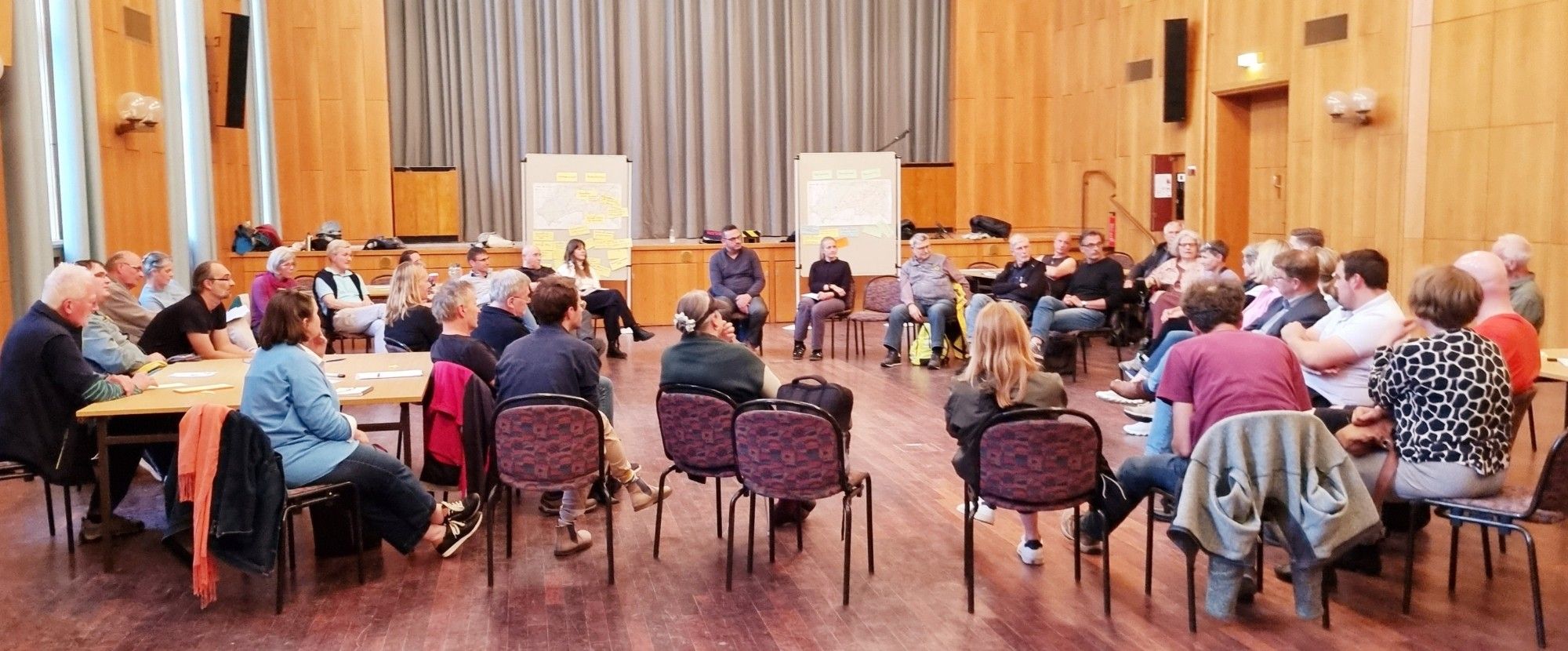 Menschen sitzen im Kreis auf Stühlen im Bürgersaal Steglitz-Zehlendorf