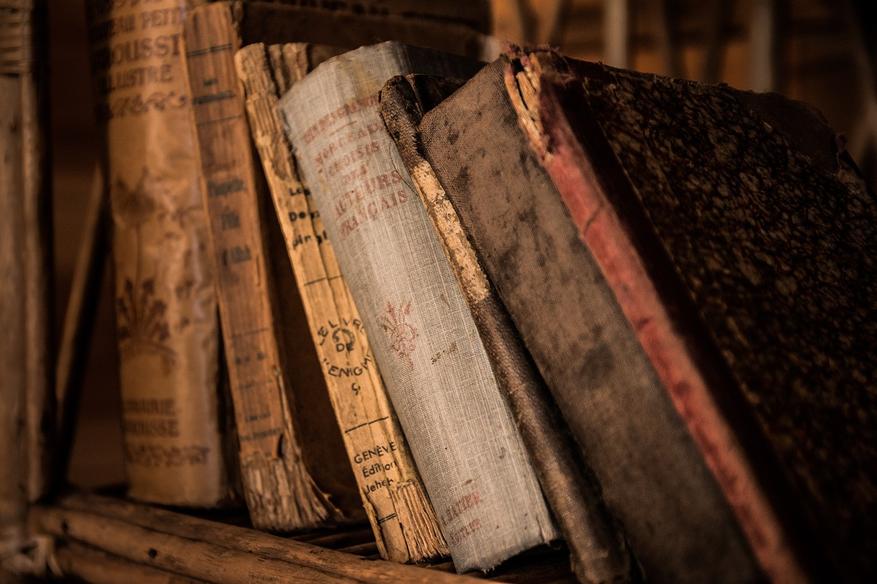 Old books tilted on a shelf