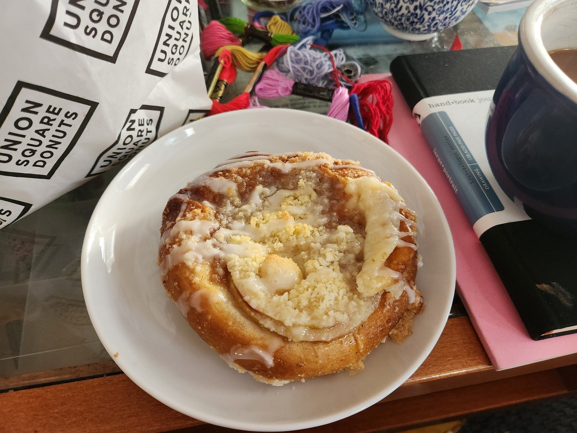 Photo of an apple Danish. It is round and covered in stressed and glaze and apple slices