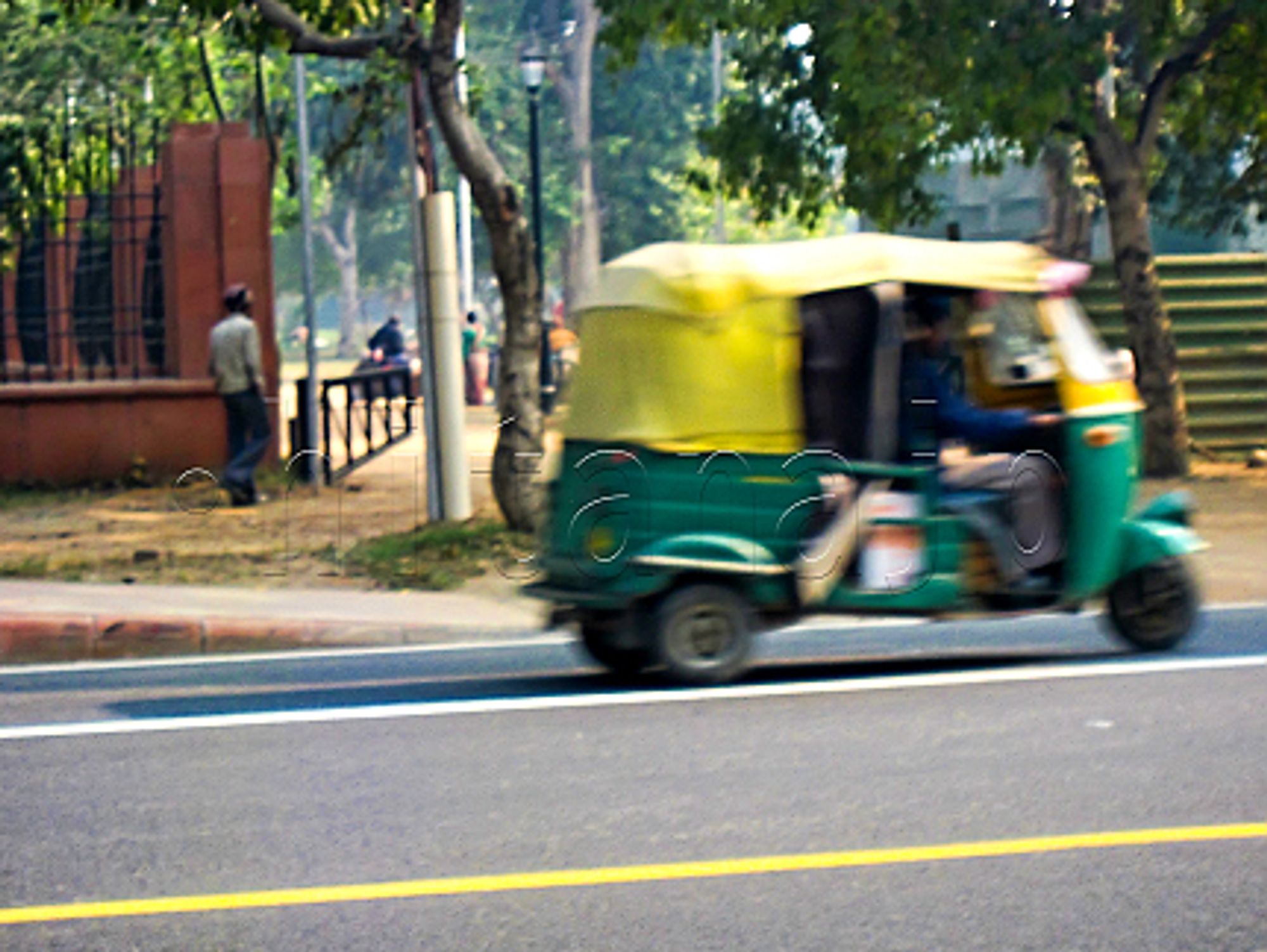 The taxi called rikisha drives away through the streets of India.