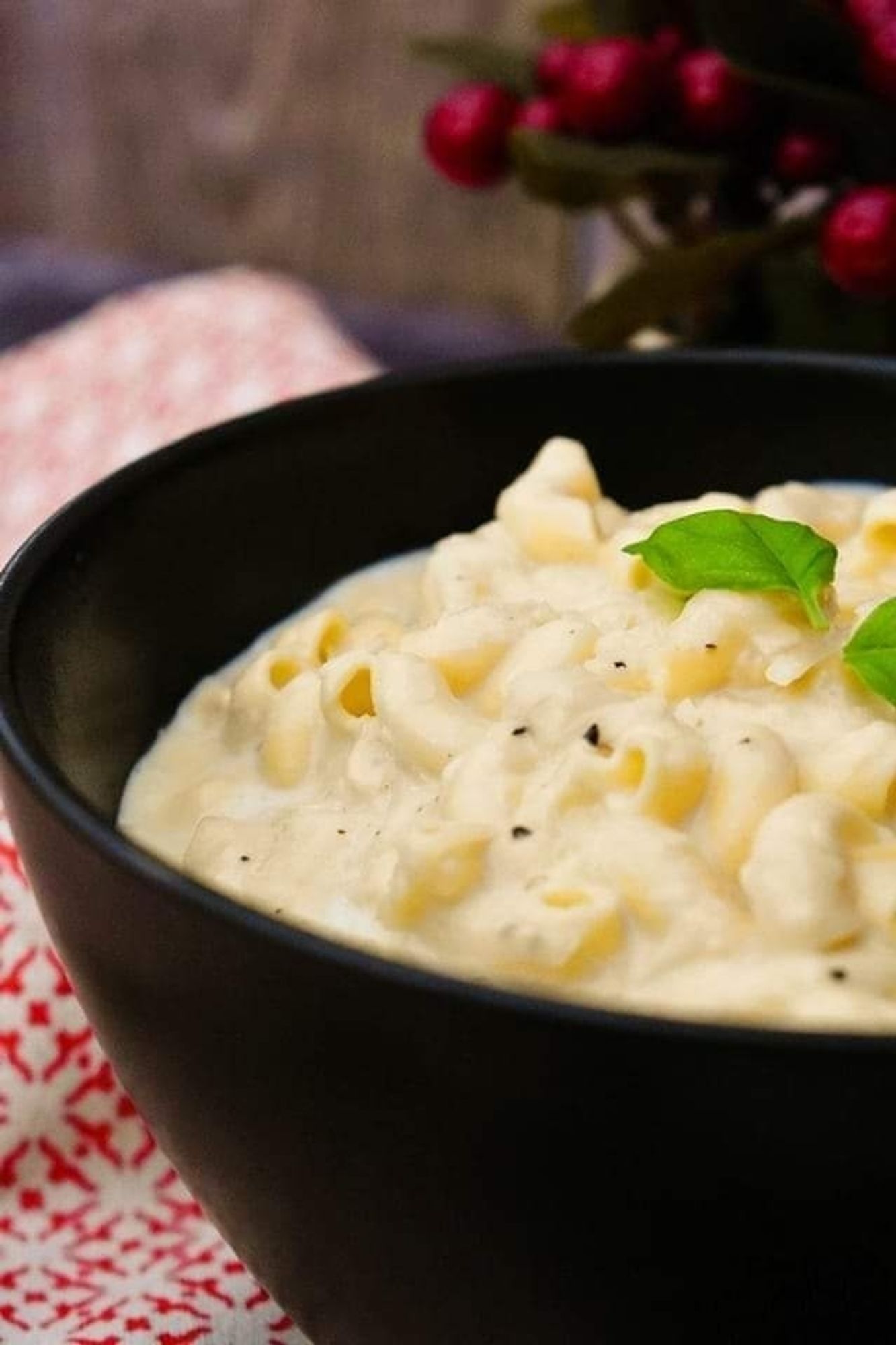 Bowl of creamy, rich macaroni cheese with lots of cheese sauce.