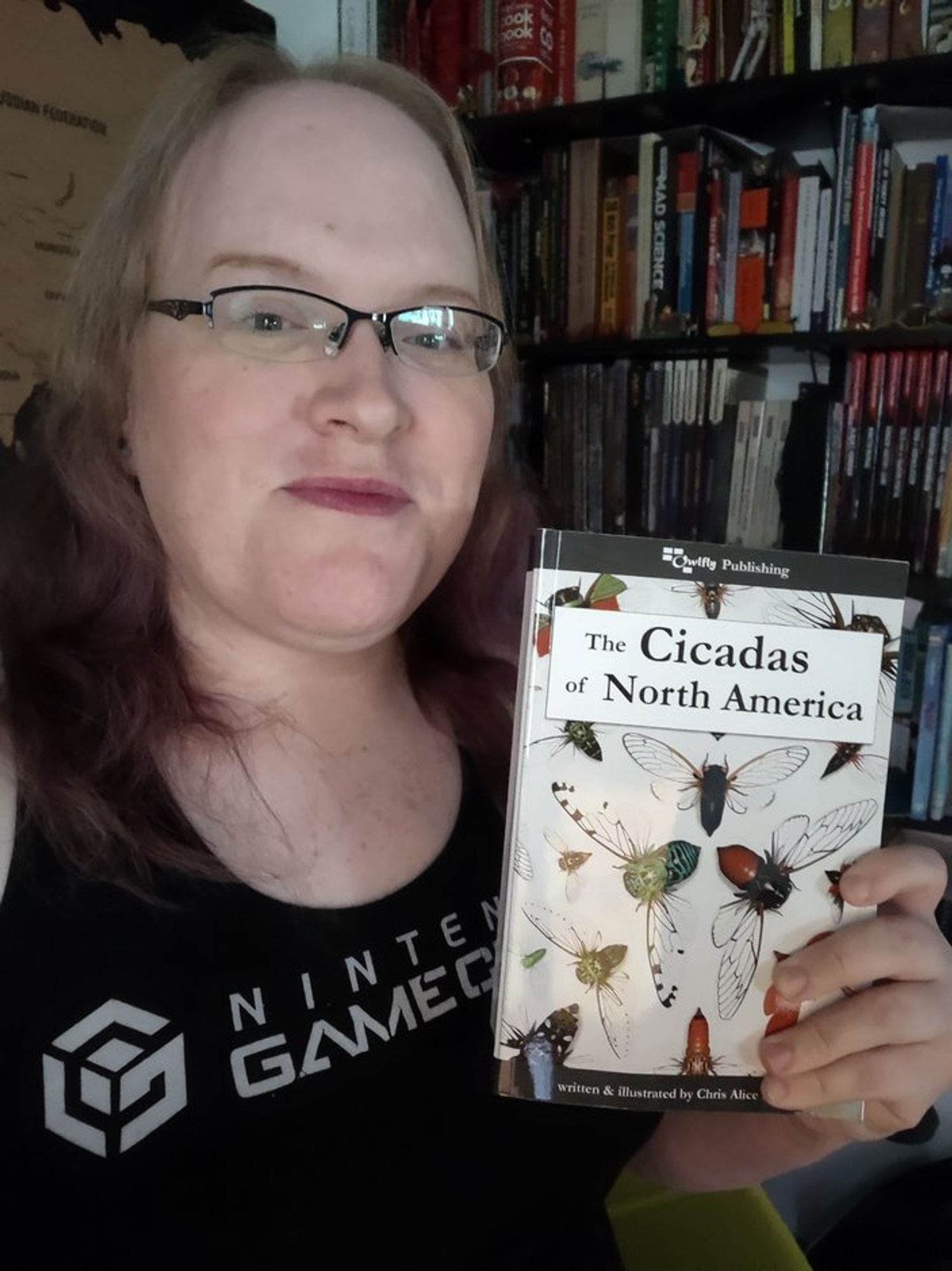 Selfie where i'm holding my copy of Alie's new cicada book. It's a low-light situation and both my jowels and double chin are super obvious. Don't look at them, look at the book!