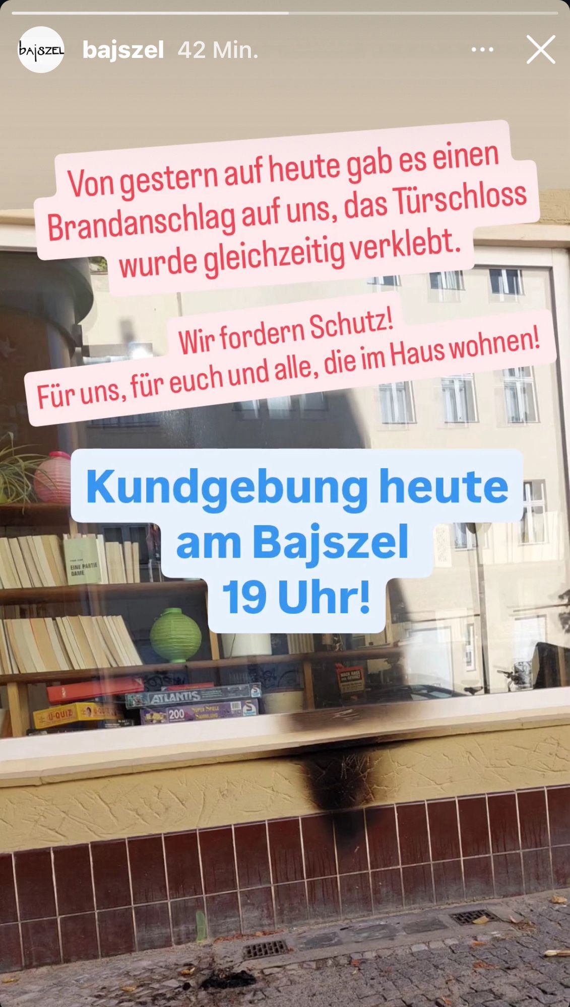 Screenshot Instagram Story vom Bajszel mit einem Bild vom Brandanschlag und dem Text:

Von gestern auf heute gab es einen Brandanschlag auf uns, das Türschloss wurde gleichzeitig verklebt.
Wir fordern Schutz!
Für uns, für euch und alle, die im Haus wohnen!
Kundgebung heute am Bajszel 19 Uhr!