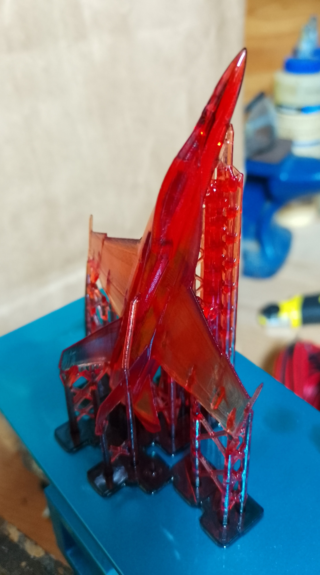 Resin printer build-plate with a printed model of a F-18 including support structures still attached.