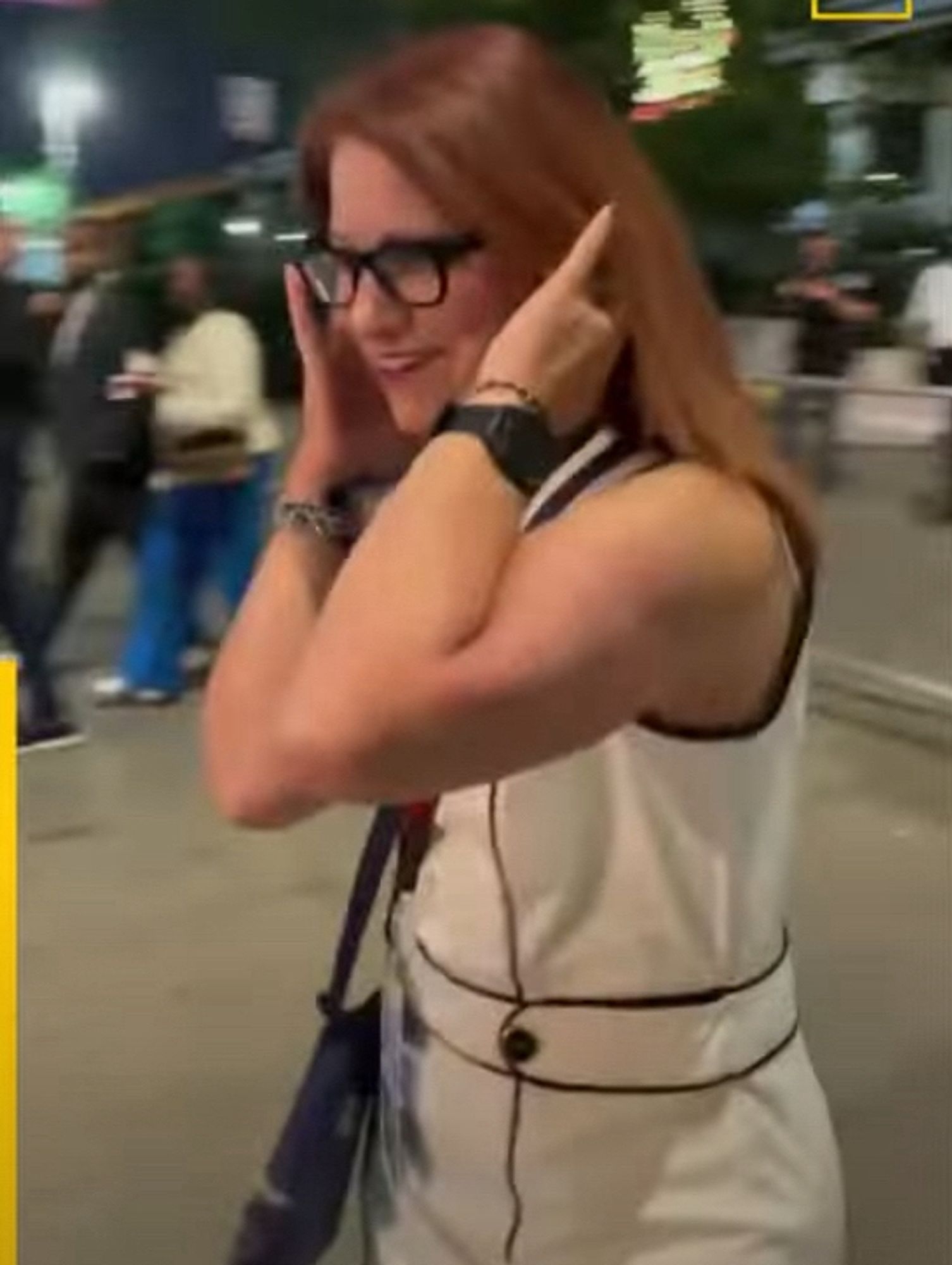 White woman with red hair covering her ears as she passes pro-Palestine protesters outside the DNC. Video here:   https://www.youtube.com/watch?v=7uVq-XSg-6M