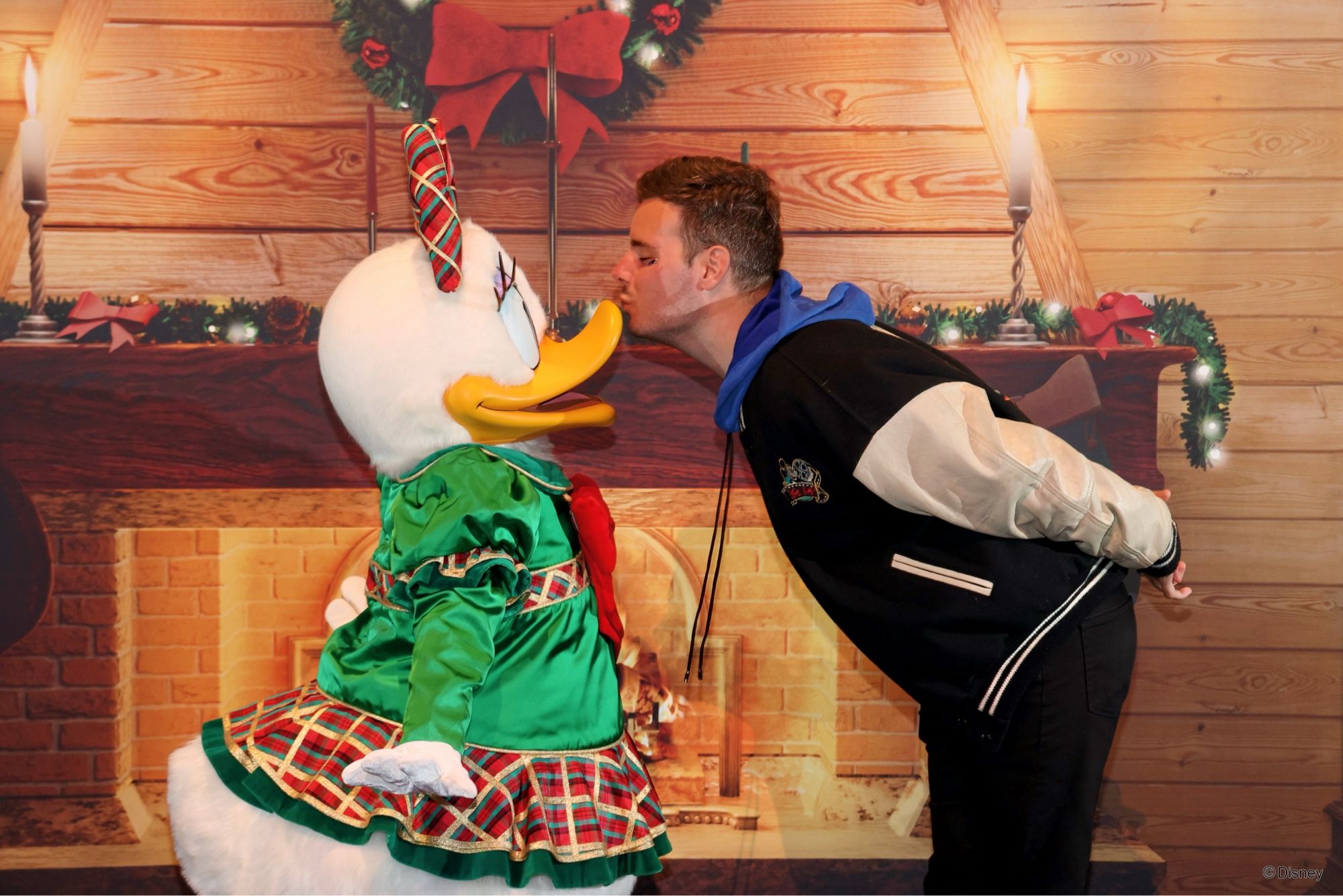 Daisy Duck en tenue de Noël ce fait embrasser sur le bec par un fan