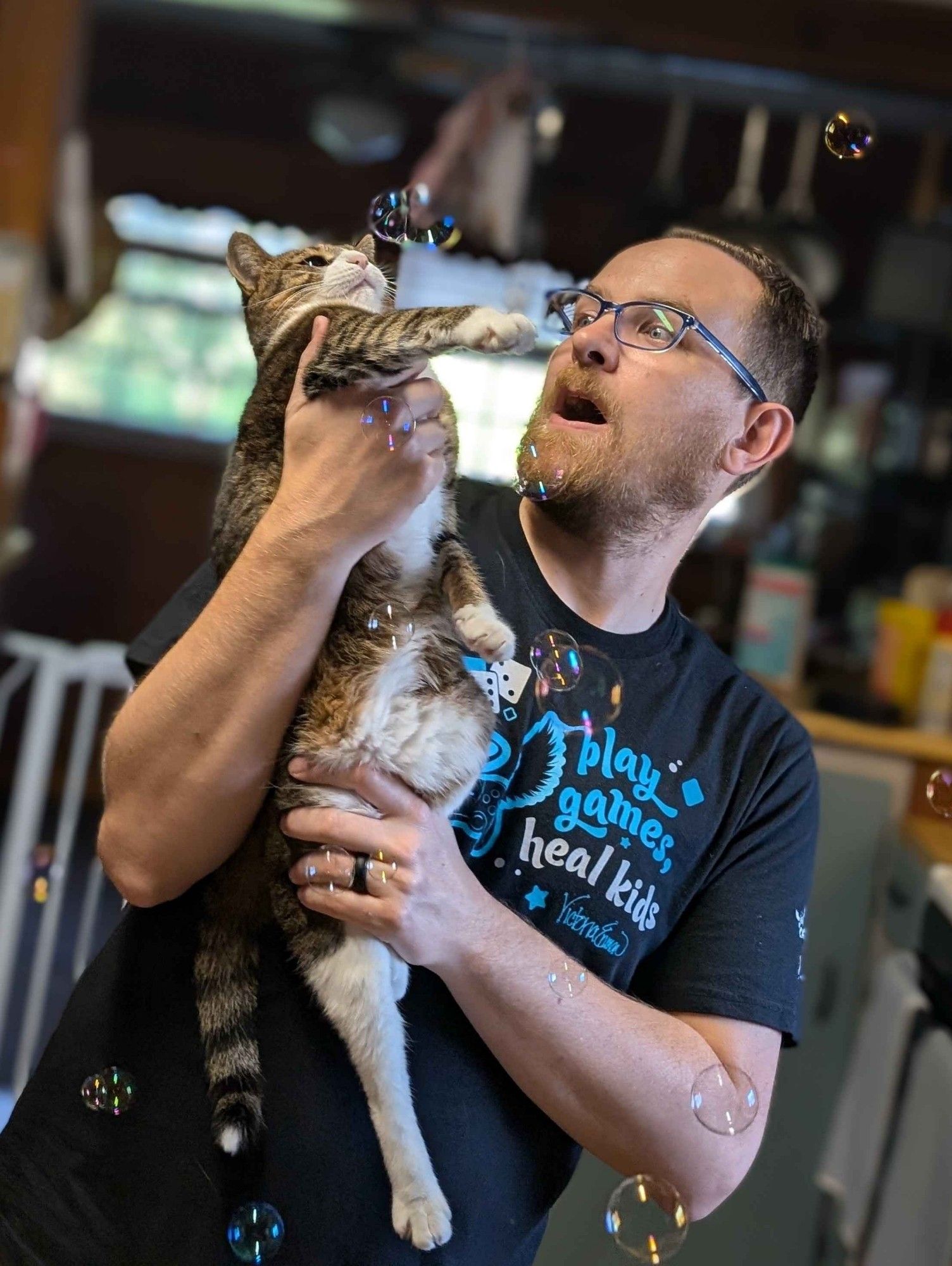 Cat dad desperately attempting to get a gremlin to enjoy bubbles