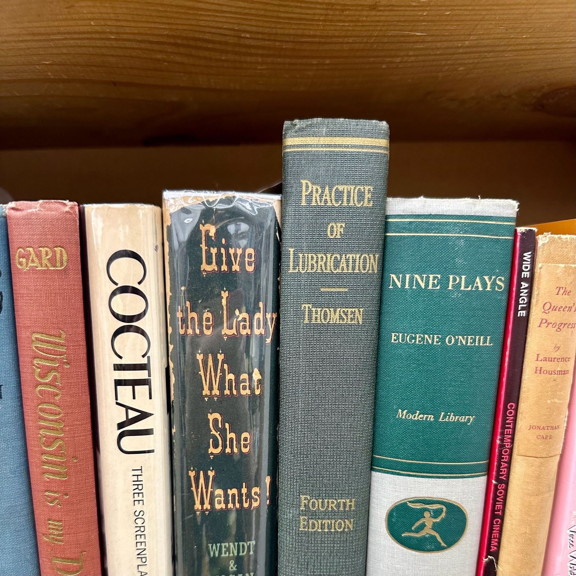 A row of used books on a shelf. The two centered books are “Give the Lady What She Wants!” and “Practice of Lubrication”.