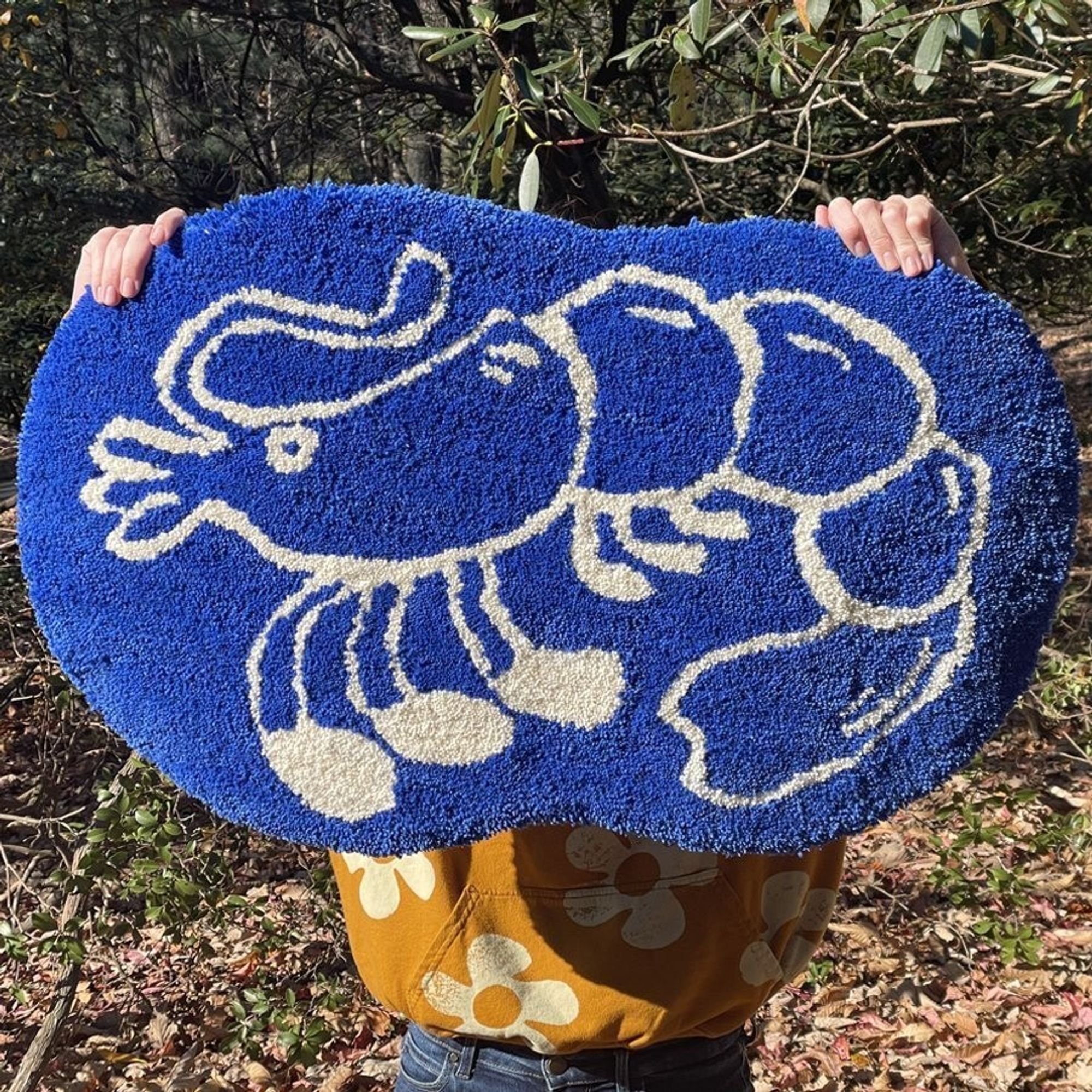 A dark blue rug with a white outlined shrimp