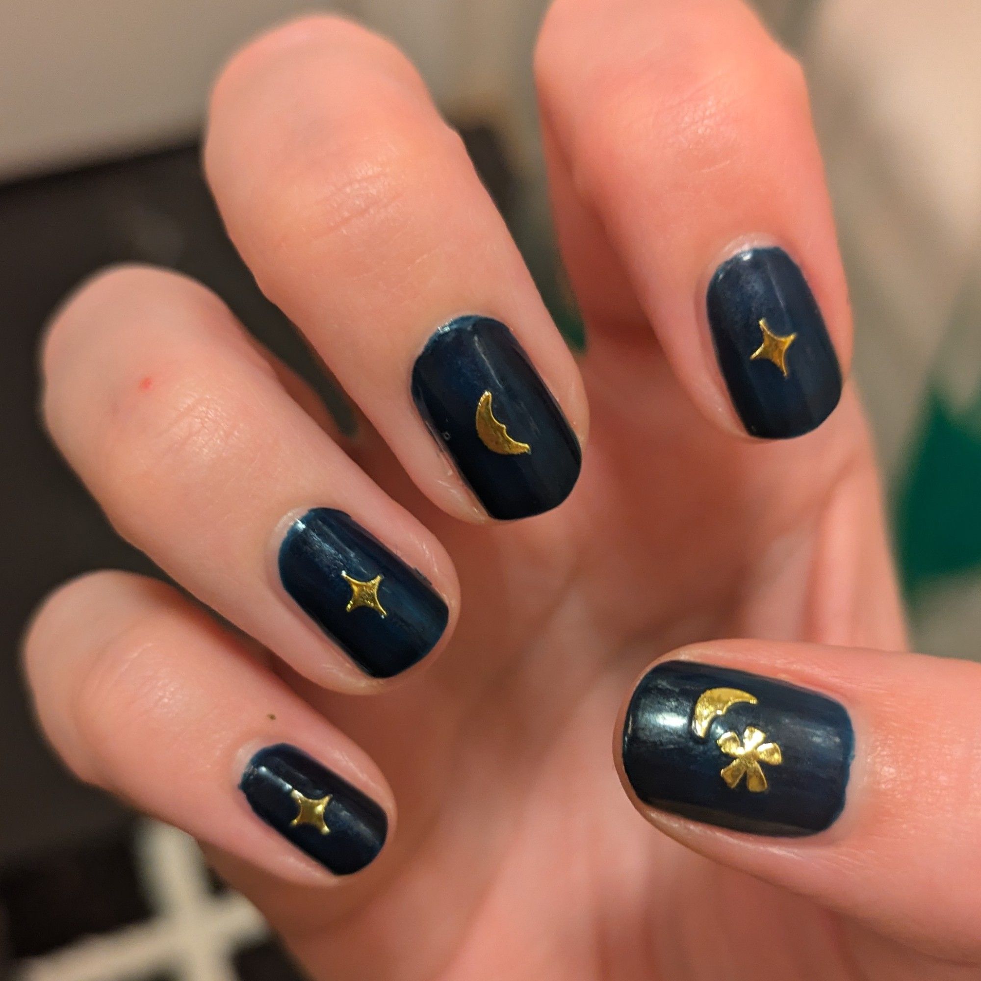 Dark blue nails with gold shiny stars and moons