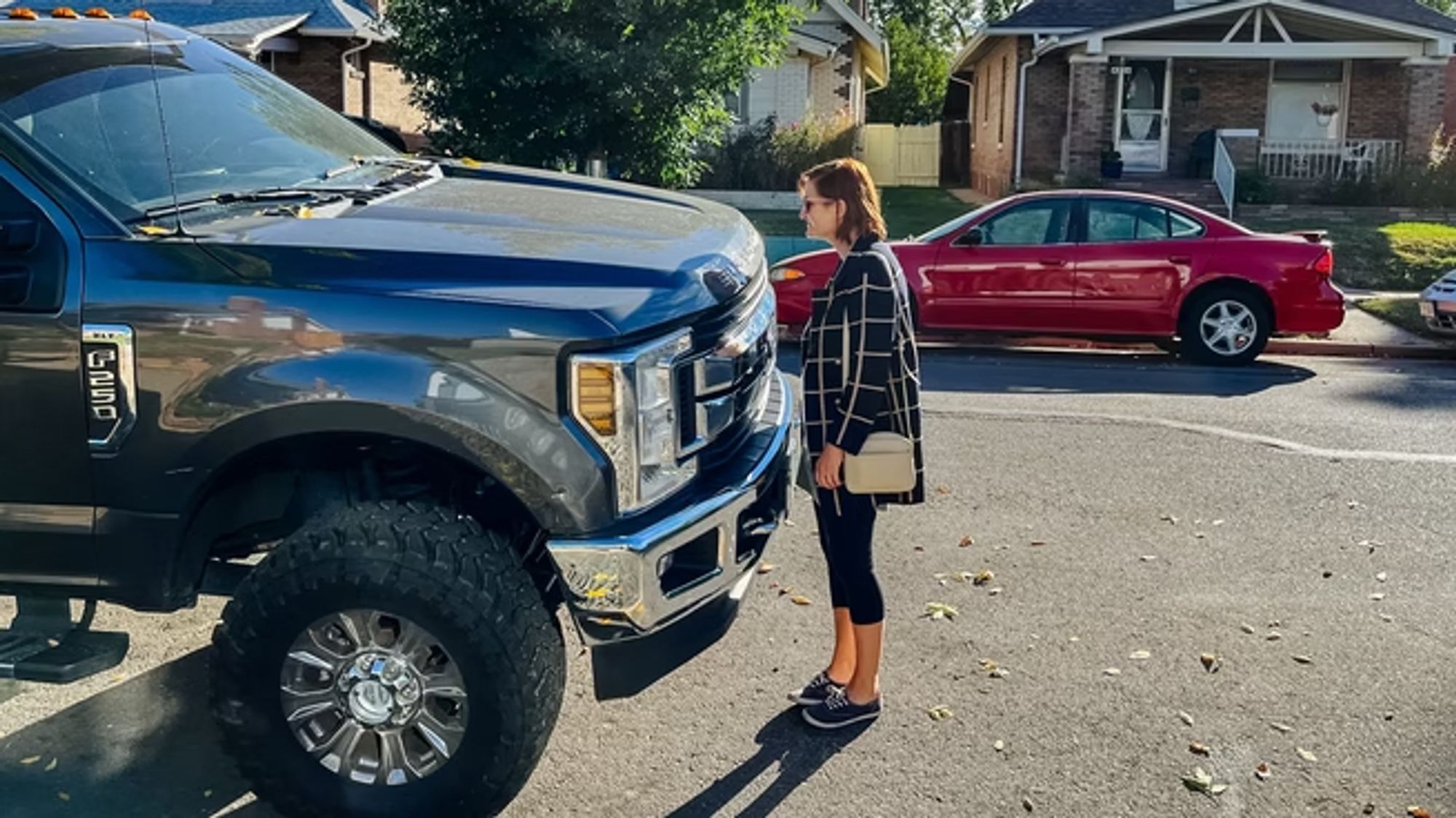 a woman standing in front of a giant pickup truck