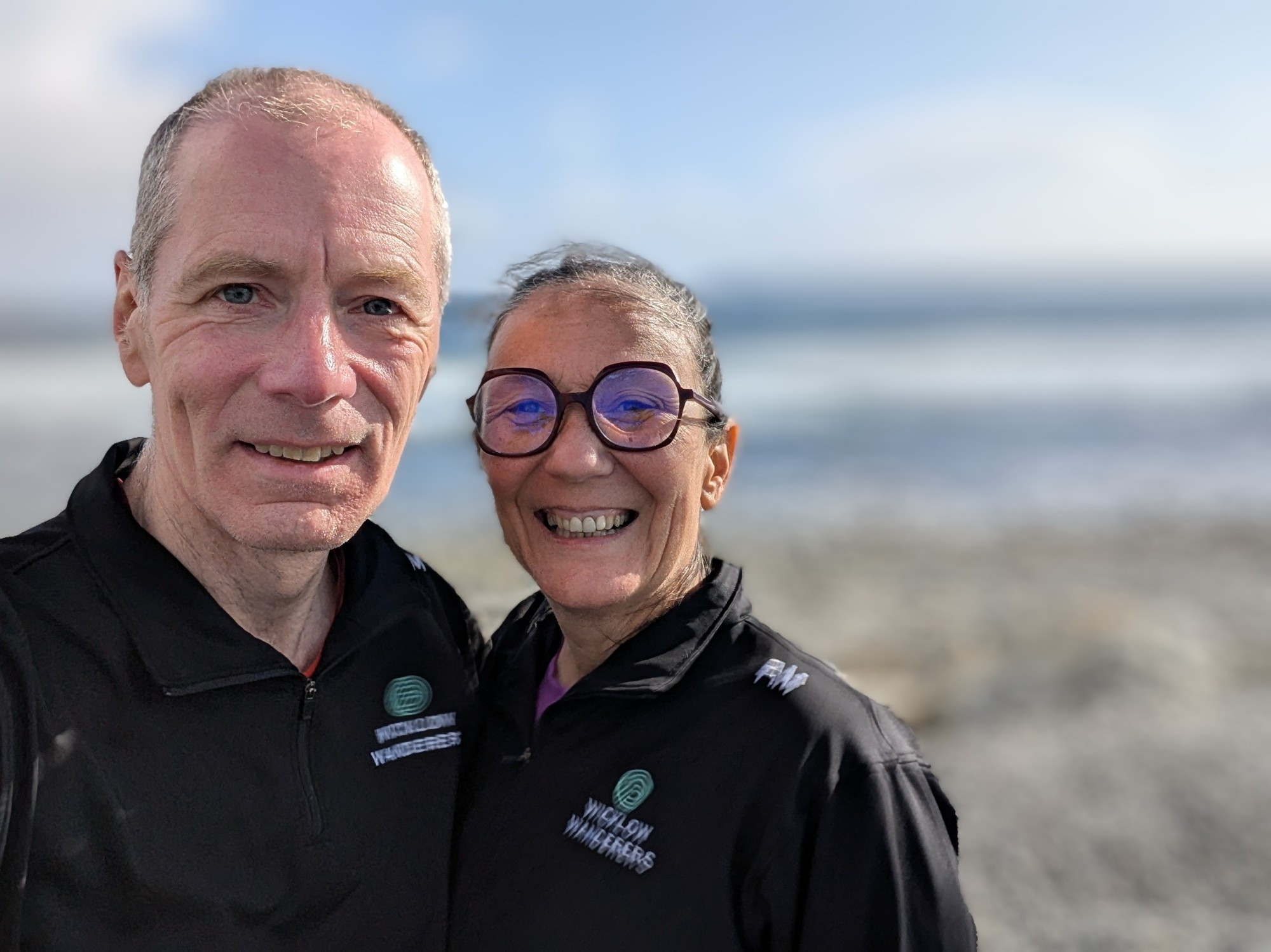 two people on a sunny beach on the Irish Atlantic coast; background showing the ocean is blurred