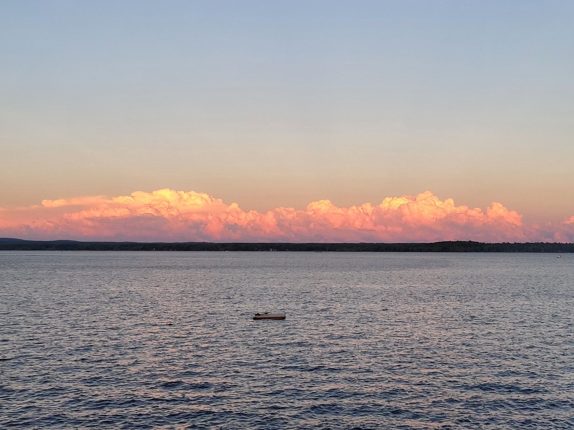 Horizon picture of water below and deep orange clouds sitting on the horizon.