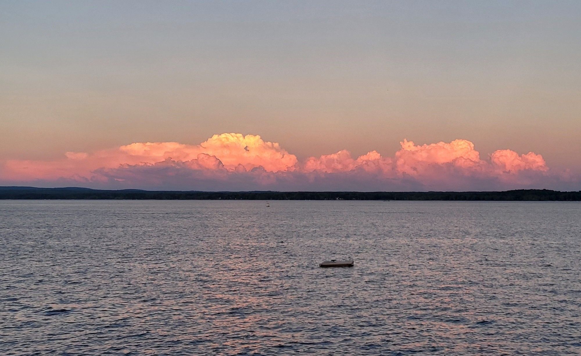 Horizon picture of water below and deep orange clouds sitting on the horizon.