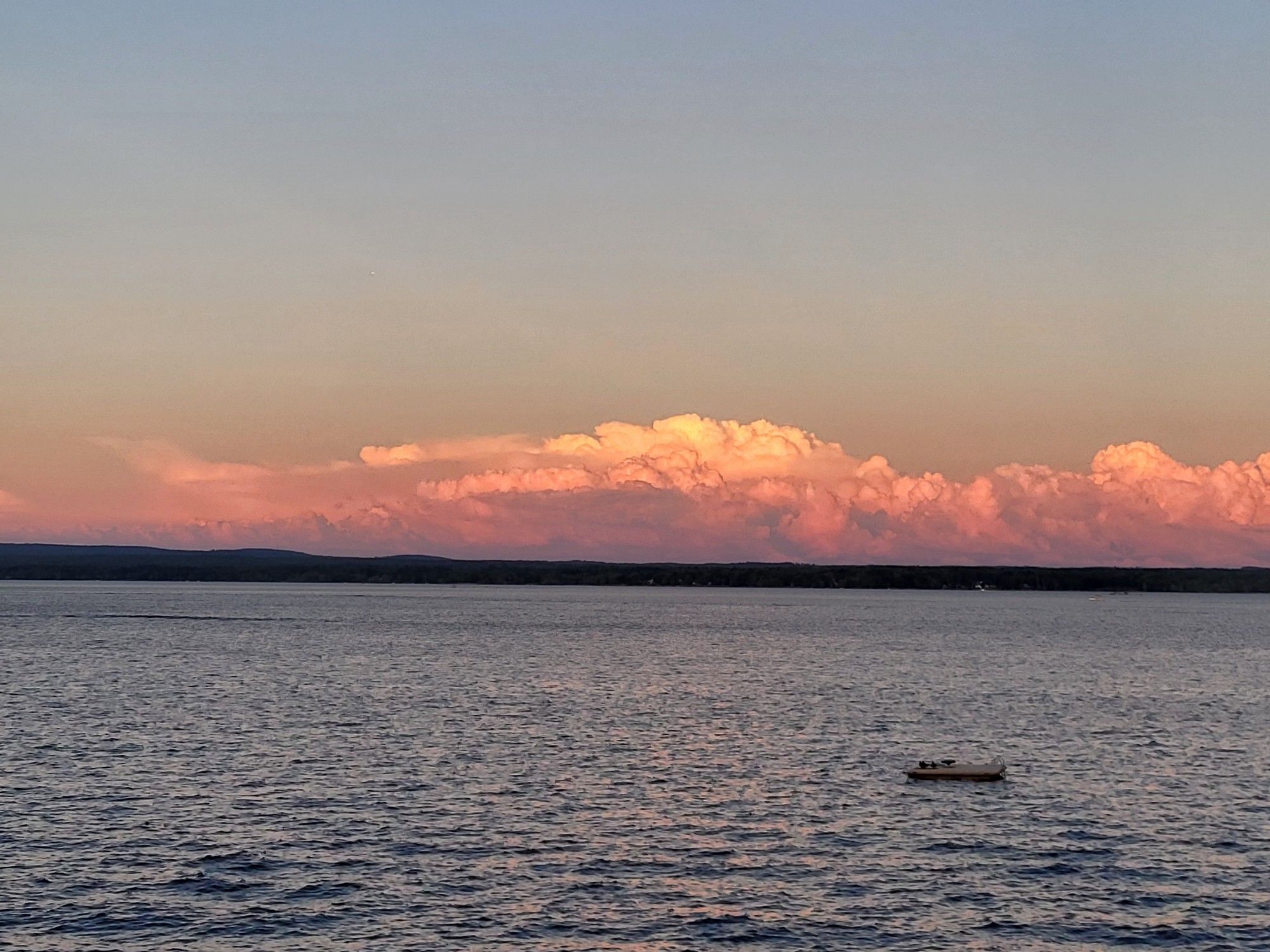 Horizon picture of water below and deep orange clouds sitting on the horizon.