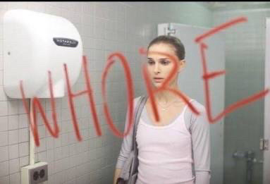 Natalie Portman in black swan looking at a bathroom mirror with whore written in lipstick 