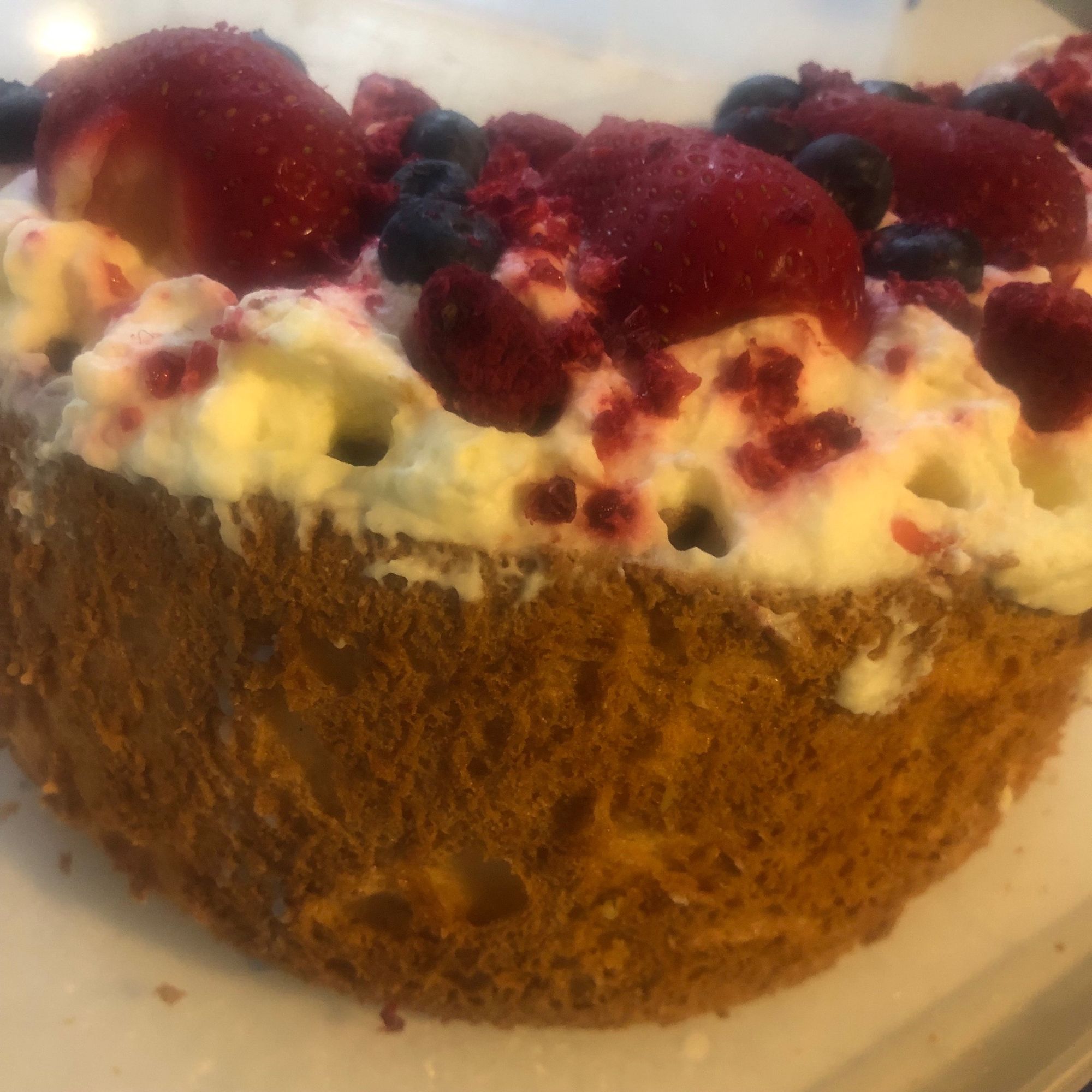 Angel food cake topped with whipped cream and fresh berries.