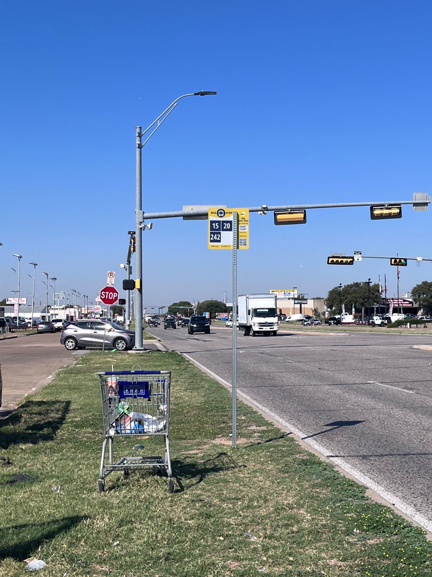 a bus stop serving three lines next to a seven lane highway without even a sidewalk, much less a bench or shelter