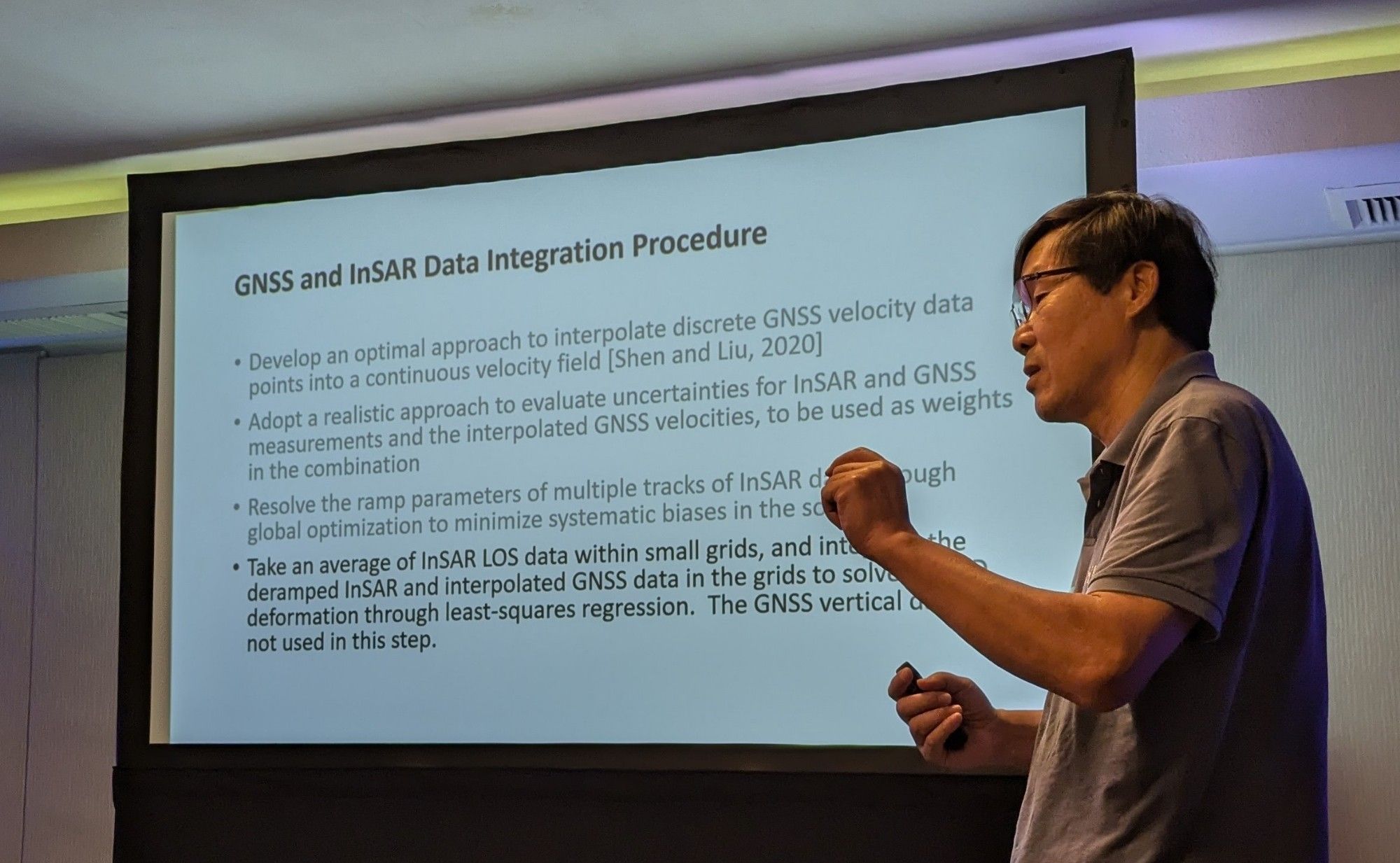 Zheng-Kang Shen standing in front of his slide on GNSS and InSAR combination