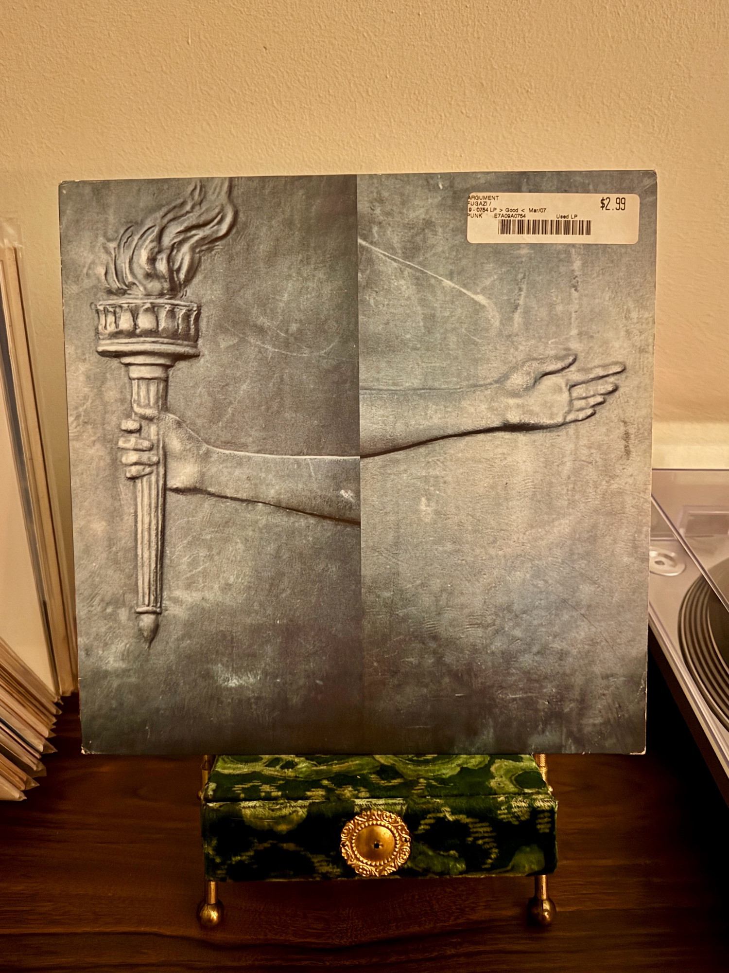 2001 copy of fugazi’s “The Argument”  on vinyl sitting on a vintage velvet Victorian photo stand.