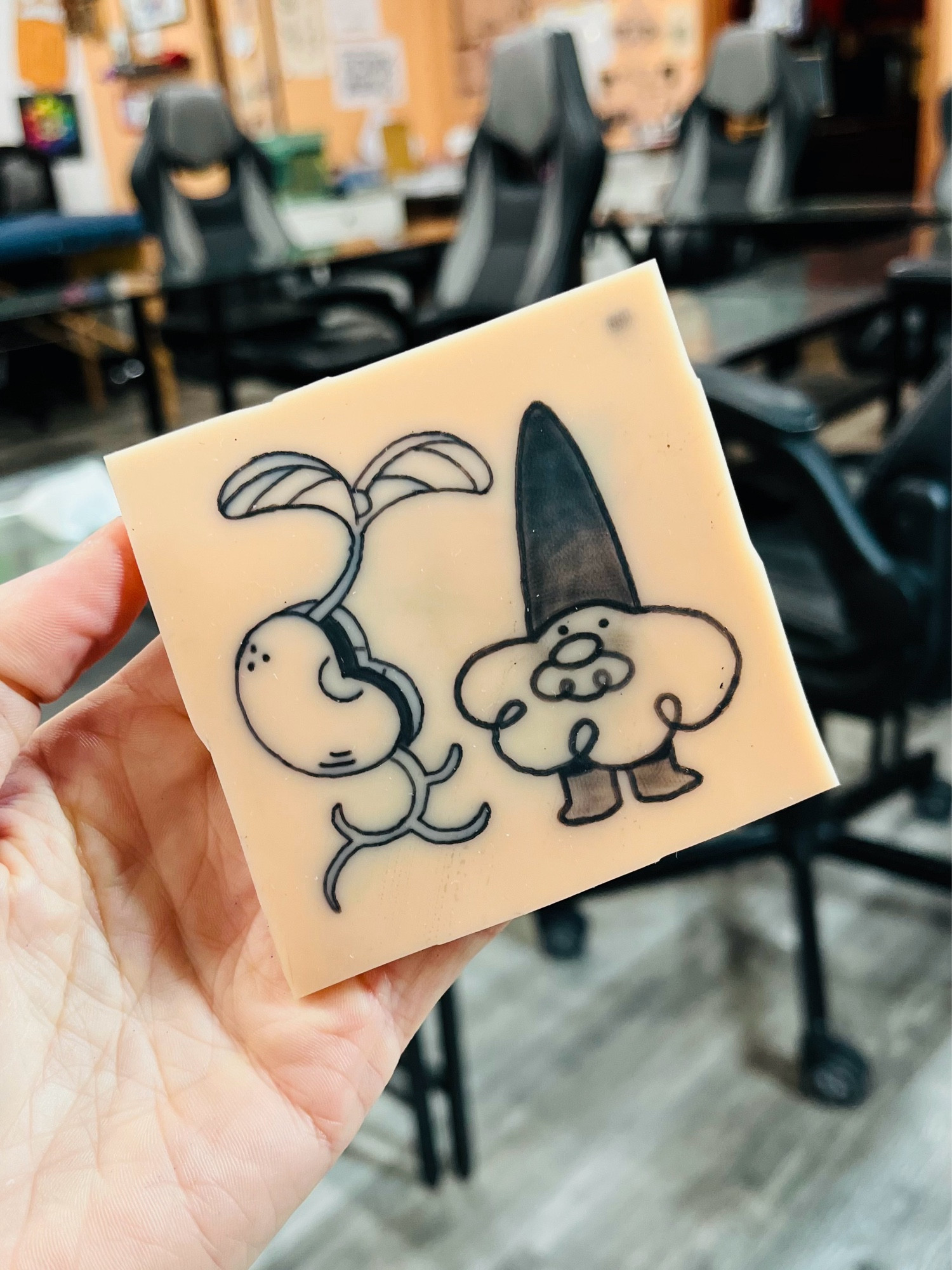 A silicone skin tattoo of a bean sprout and a cartoon gnome