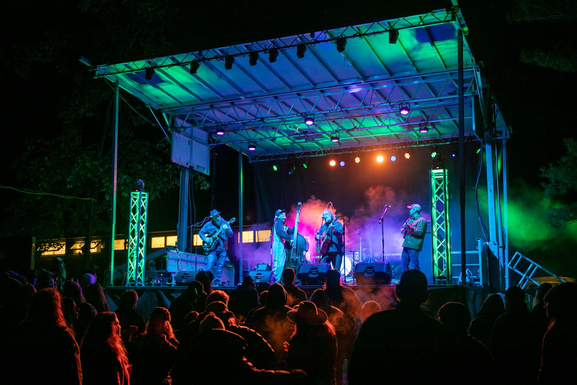 Photograph of Woodbox Gang lit up in green and blue playing to a large crowd at Little Grassy Get Down Festival.