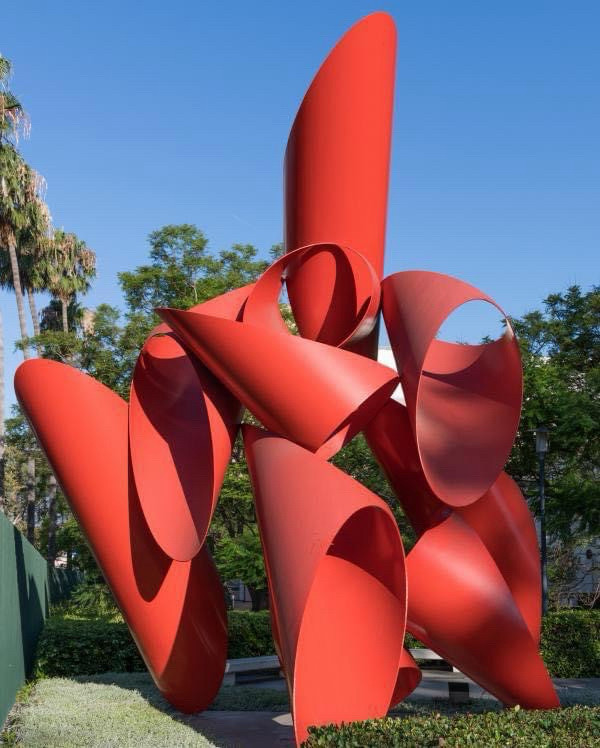 Red metal outdoor sculpture, made up of a collection of truncated cone type shapes