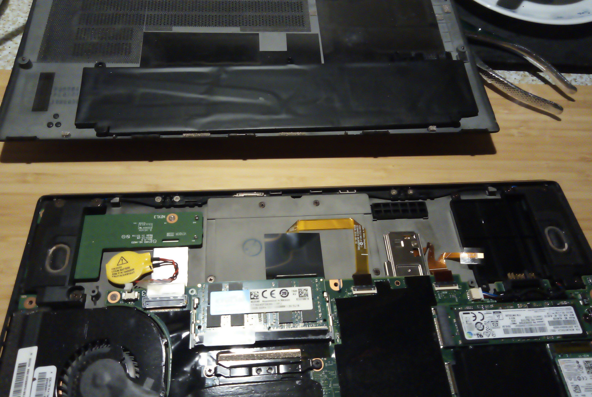 components of a laptop, the battery is removed from the motherboard.