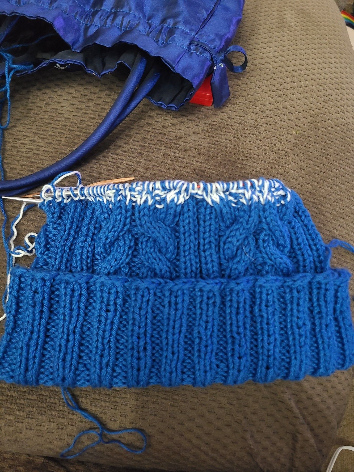 Cable double knit beanie in blue with the start of an ombre.