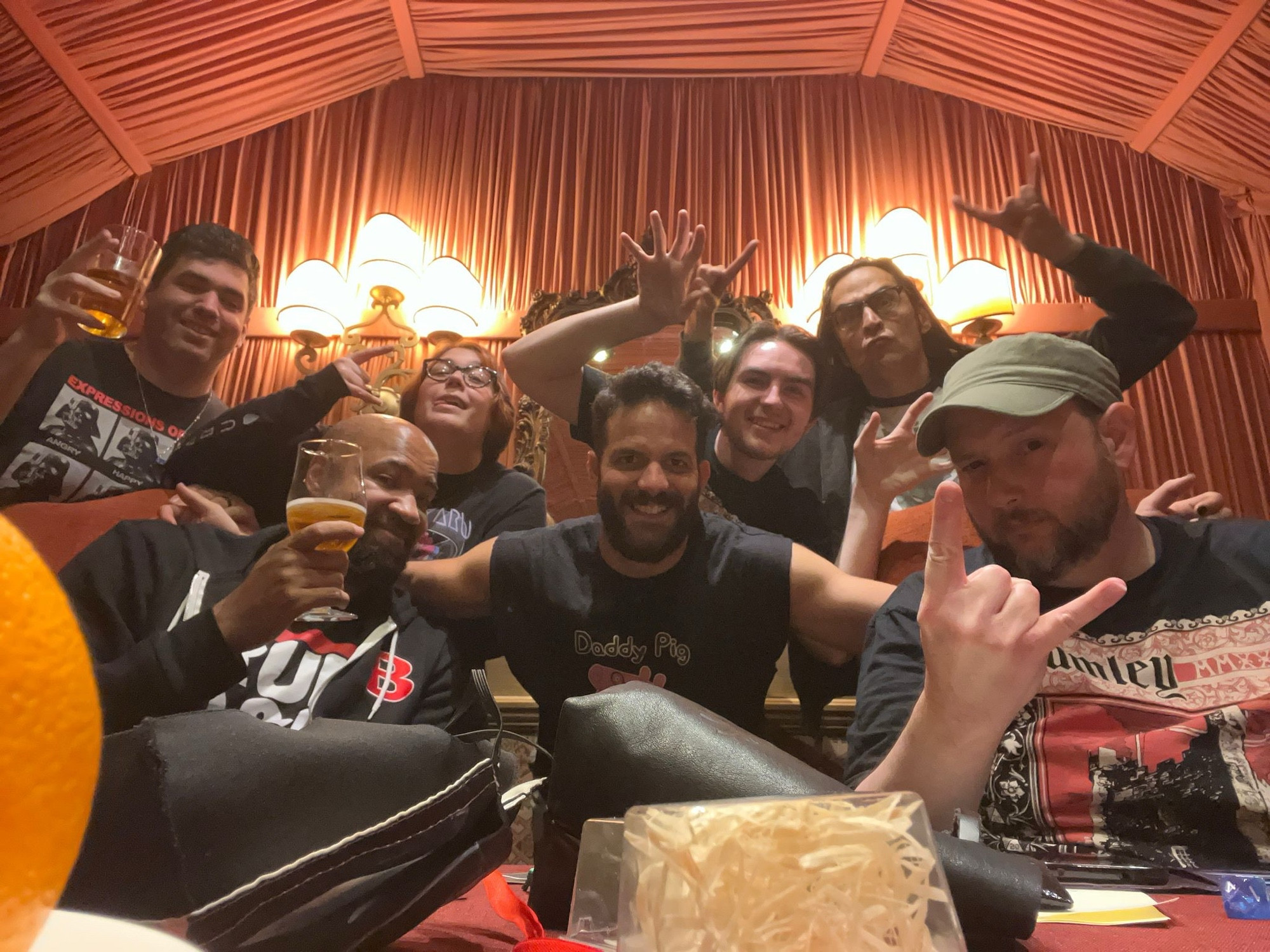 Erik, B. Dave Walters, Mark Meer, Jo Levin, and others at D&D in a Castle. Erik is wearing a green hat and a D&D in a Castle Staff shirt. Everyone is posing for the camera 