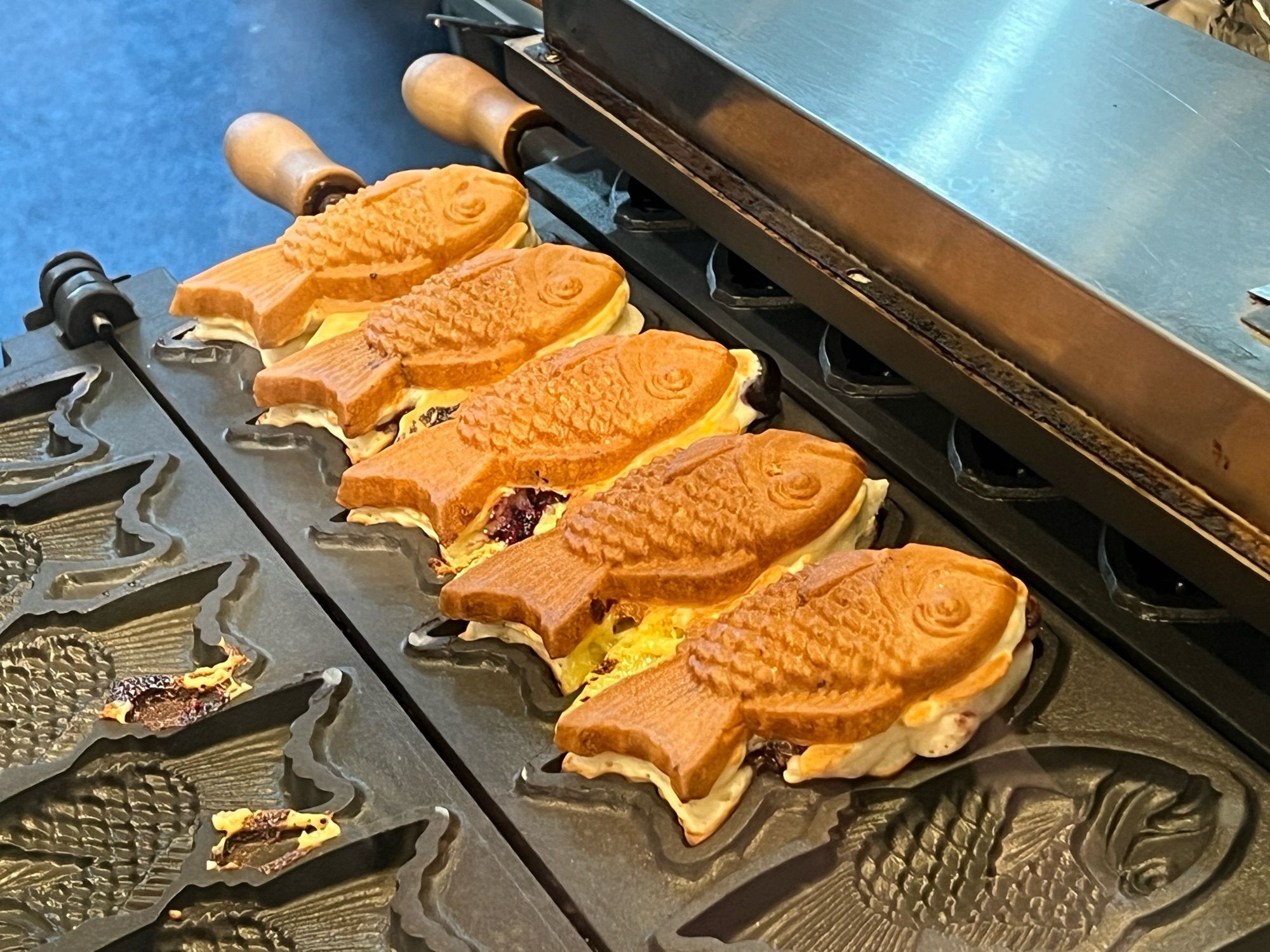 Taiyaki (fish-shaped pastries) being grilled.