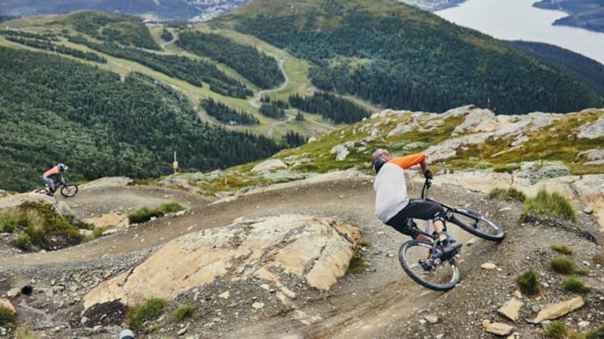 Person cyklar på en stig med bankade kurvor nerför ett berg