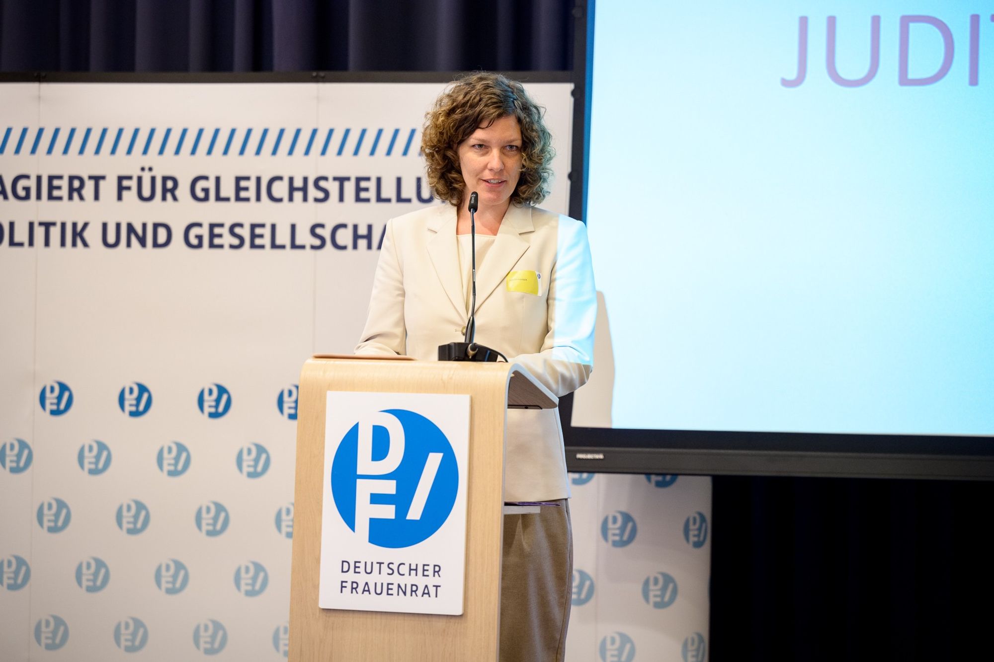 Foto von Judith Rahner am Redner*innenpult bei der DF-Mitgliederversammlung