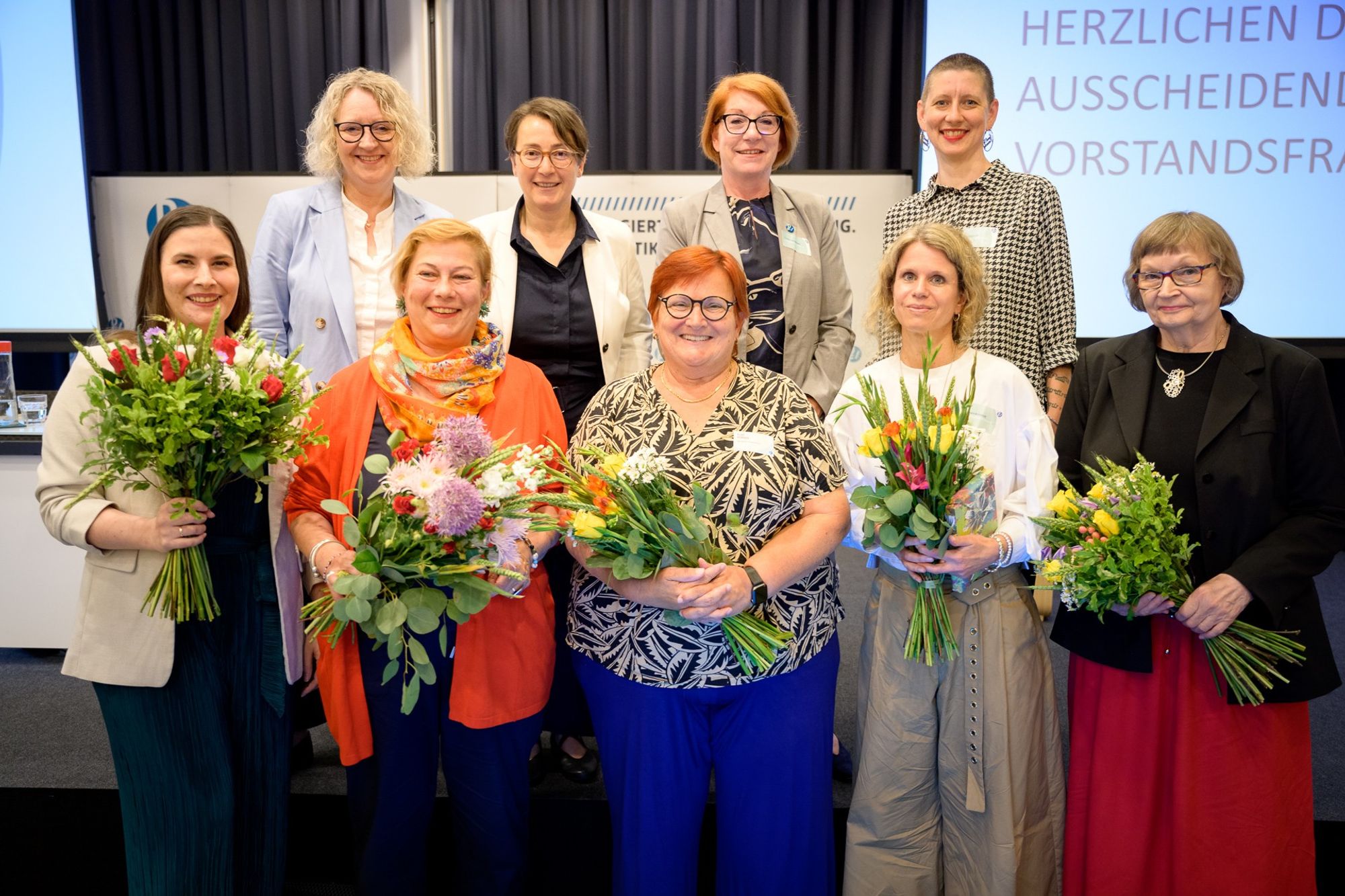 Gruppenbild Vorstand mit Sonderbeauftragten Susanne Kahl-Passoth mit Blumensträußen