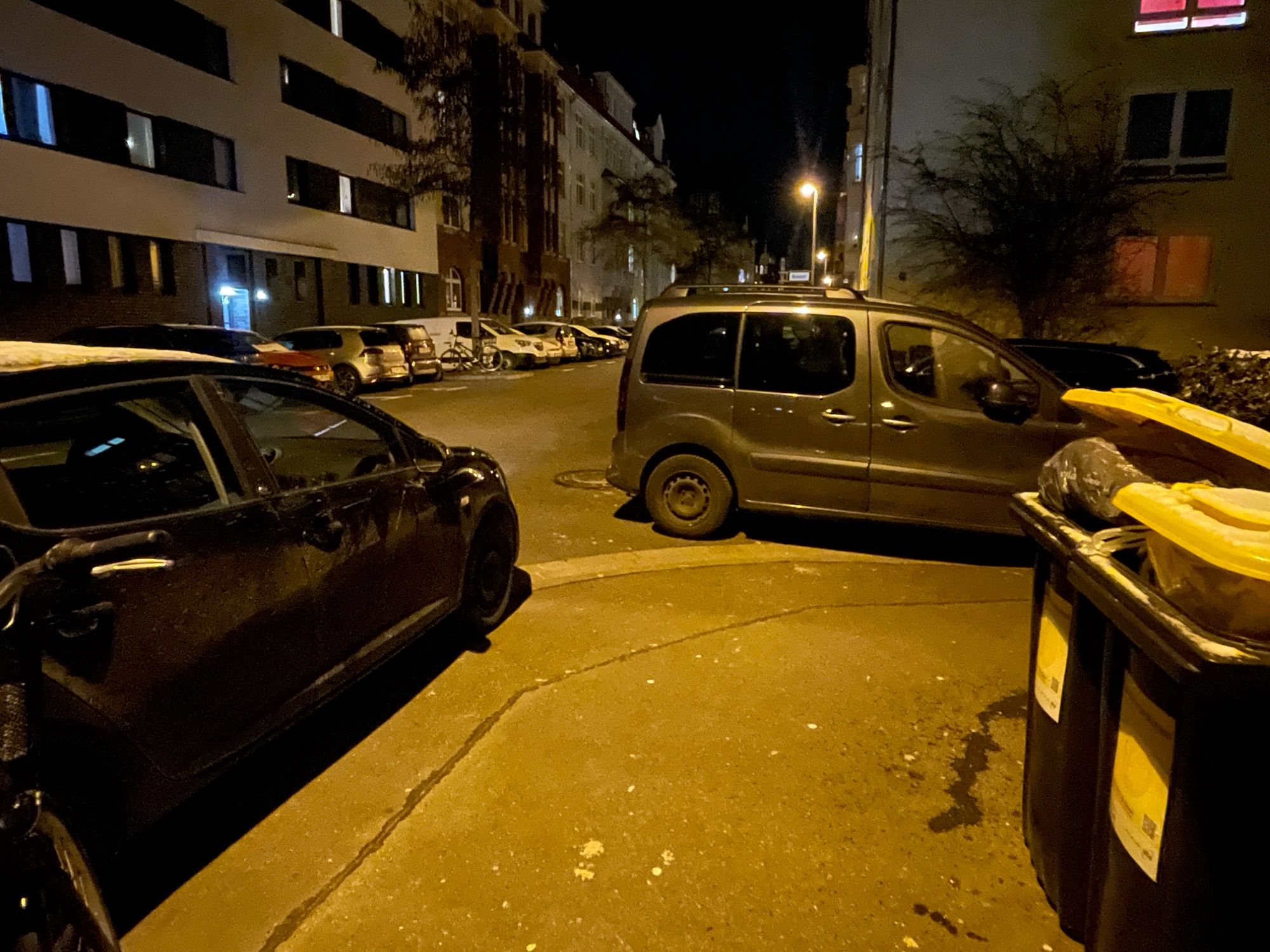 Zwei PKW wurde im rechten Winkel zu einander an einer Straßenecke geparkt. Für Zufußgehende bleibt nur eine schmale Lücke, um vom Gehweg auf die Fahrbahn zu kommen.