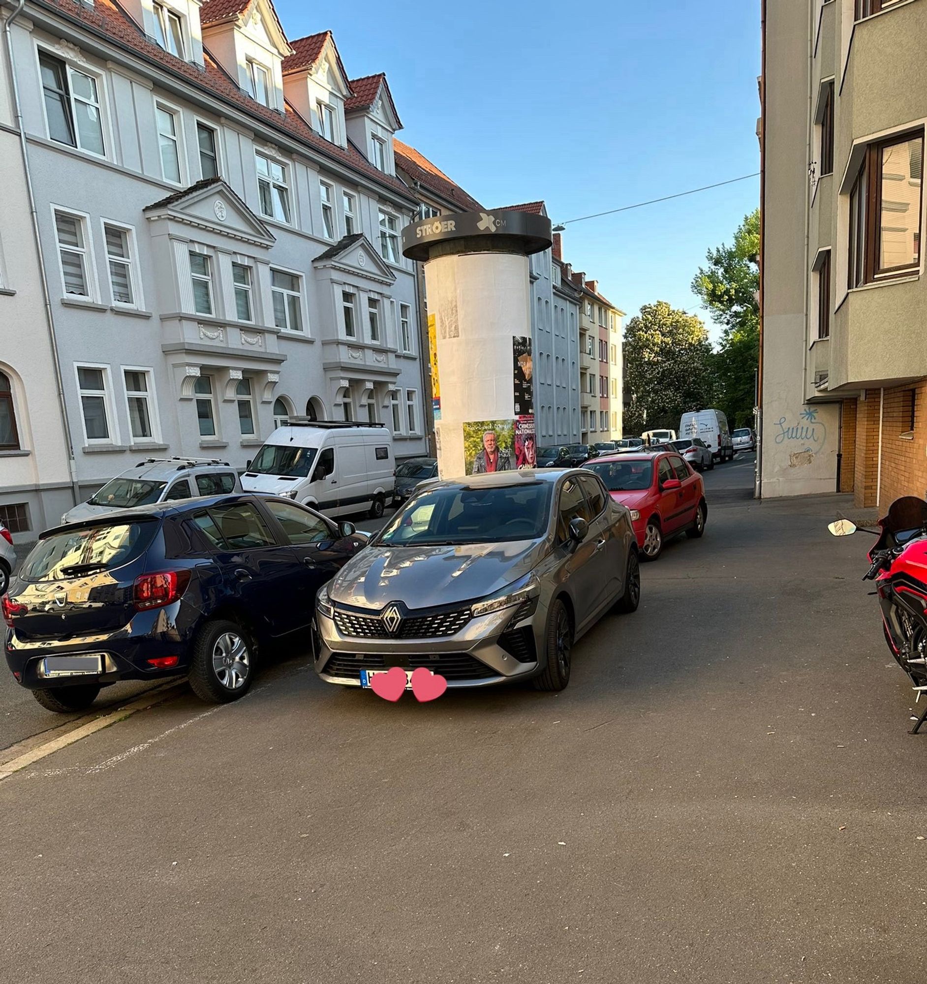 Blick entlang eines Gehwegs. Zwei Fahrzeuge wurden auf diesem geparkt