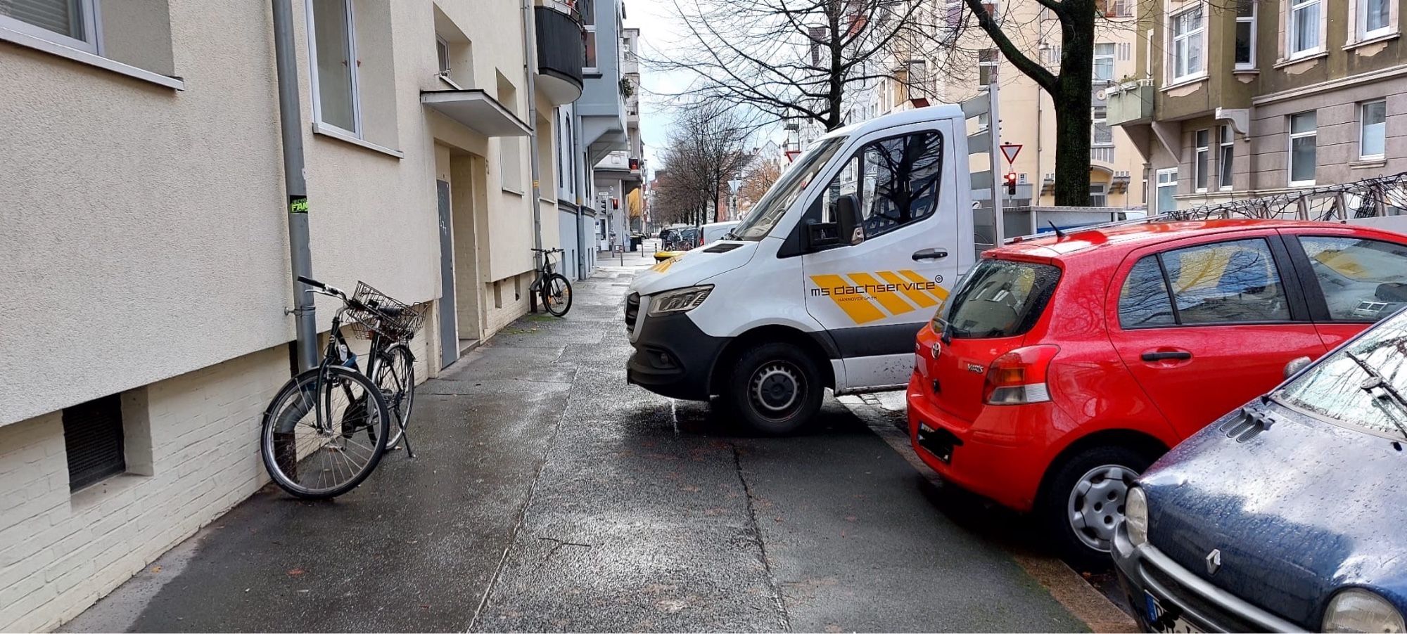 Ein Transportfahrzeug wurde auf einem Querparkplatz abgestellt. Das Fahrerhaus steht dabei auf dem Gehweg