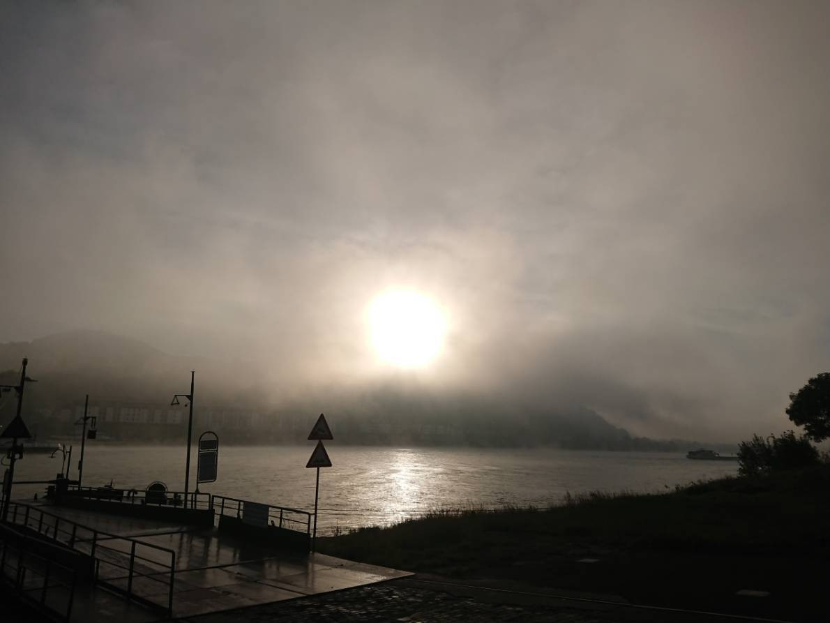 Photo of the Rhine River in Bonn, Germany, early in the morning with the sun behind morningfog.