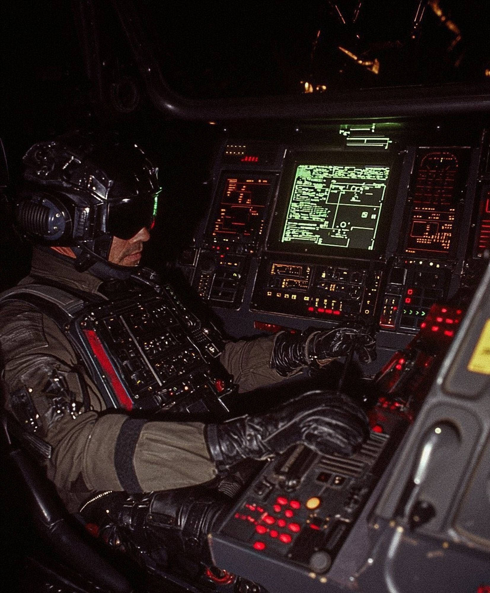 Person in futuristic pilot gear seated in a cockpit with multiple screens and control panels, operating the controls.