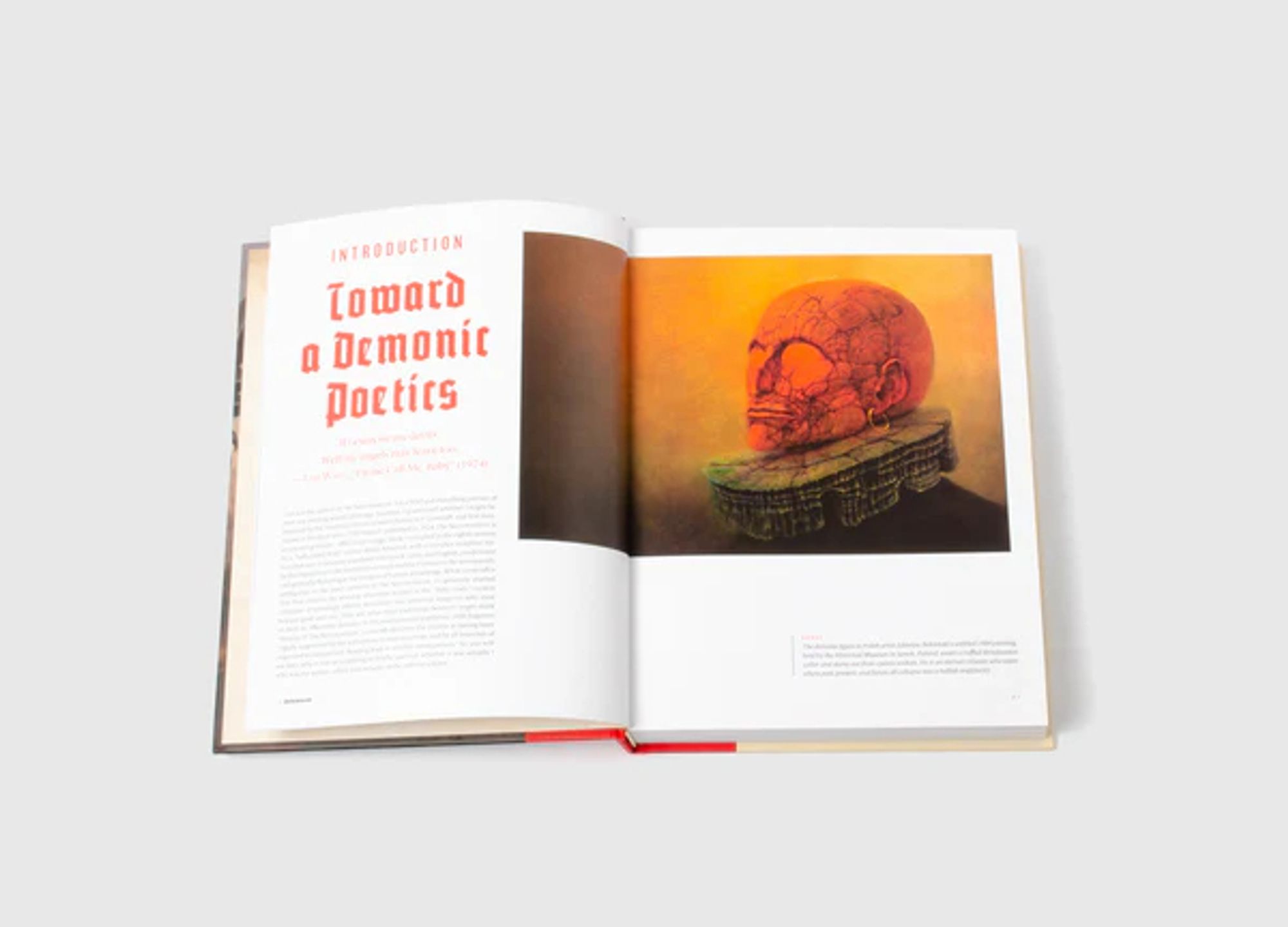 Two page interior spread. 

Left page: in red blackletter typeface: 
Introduction
Toward a Demonic Poetics

Right page: Zdzislaw Beksinski's untitled 1984 painting of a demonic man's head, rendered in orange, his skin tough like a fruit peel and shot through with cracks. He is wearing a stony, chipped ruffled Renaissance collar who "stares out of eyeless sockets. He is an eternal creature who exists where past, present, and future all collapse into a hellish singularity."