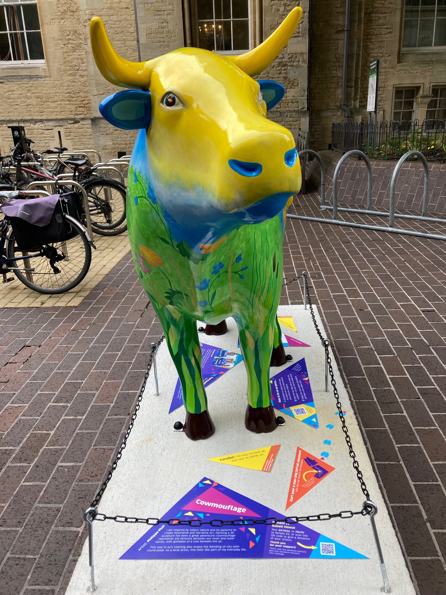 front view of ox sculpture with yellow head and green legs which is meant to be the grassy fields