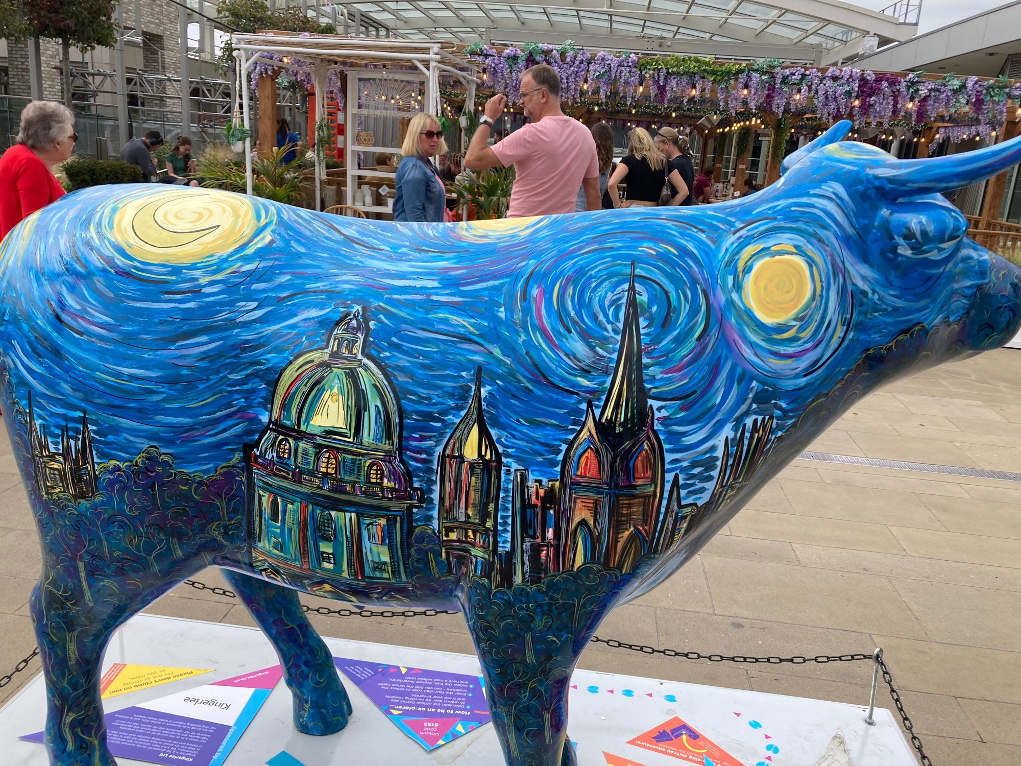 other side of ox sculpture in style of starry night by van gogh. Oxford skyline and deep blue sky and yellow swirls above