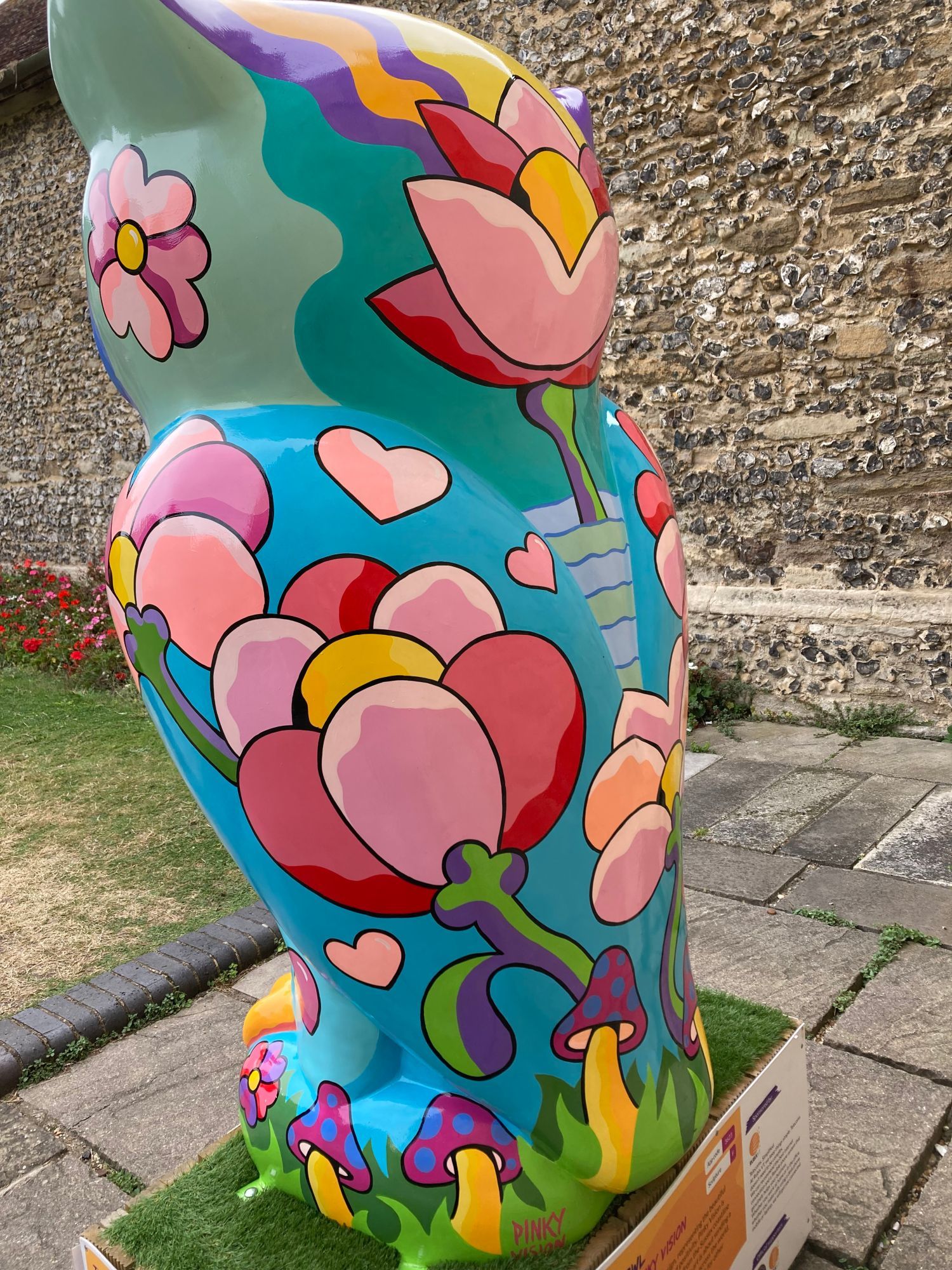 back view of large owl, blue with pink flowers and toadstools painted on