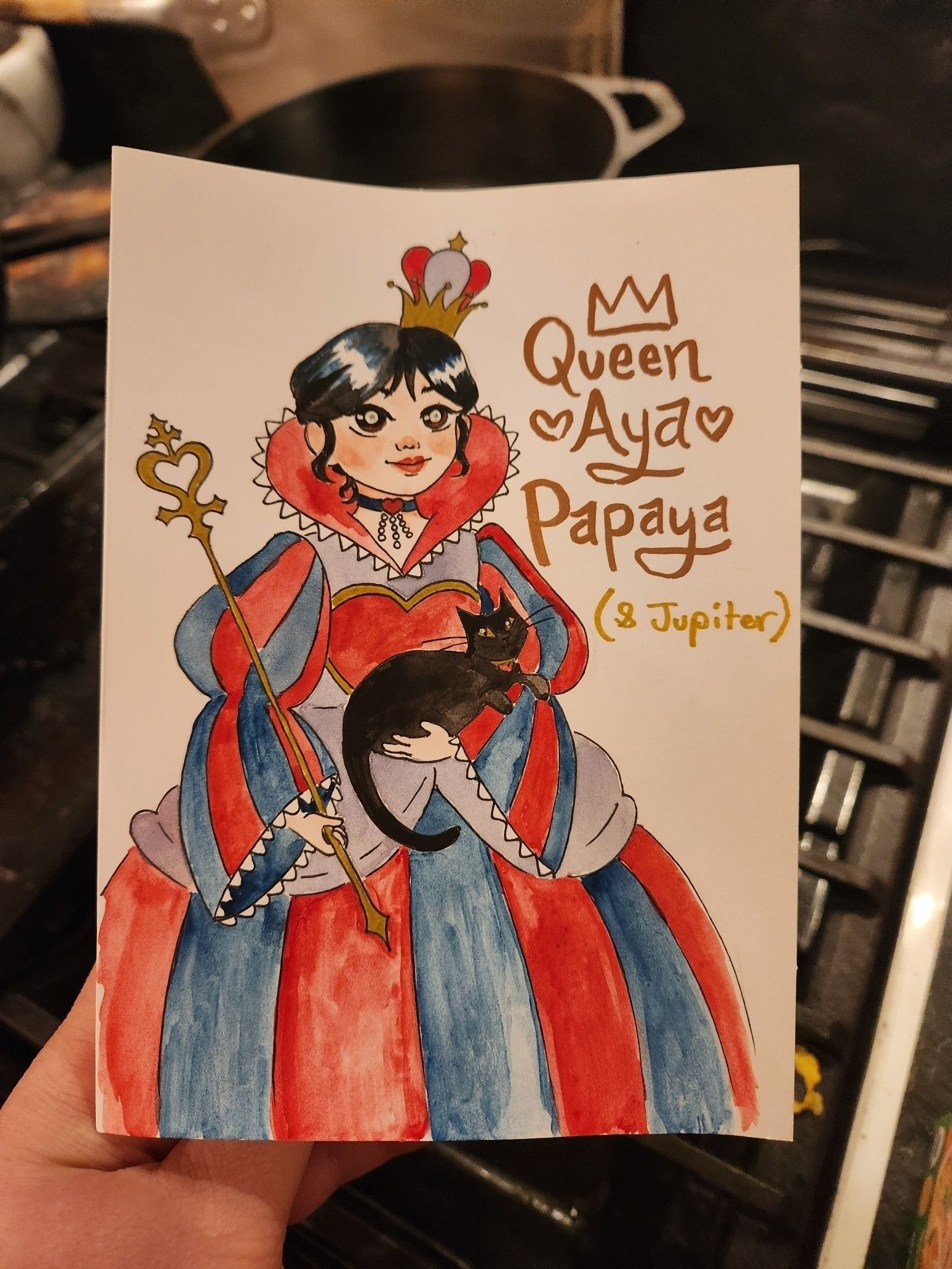 A photo of a hand drawn and painted card for a 4 year old. It shows a cartoon girl dressed as a queen and holding a black cat in one arm, and a sceptre in the other. The card reads "queen Aya papaya (&Jupiter)"