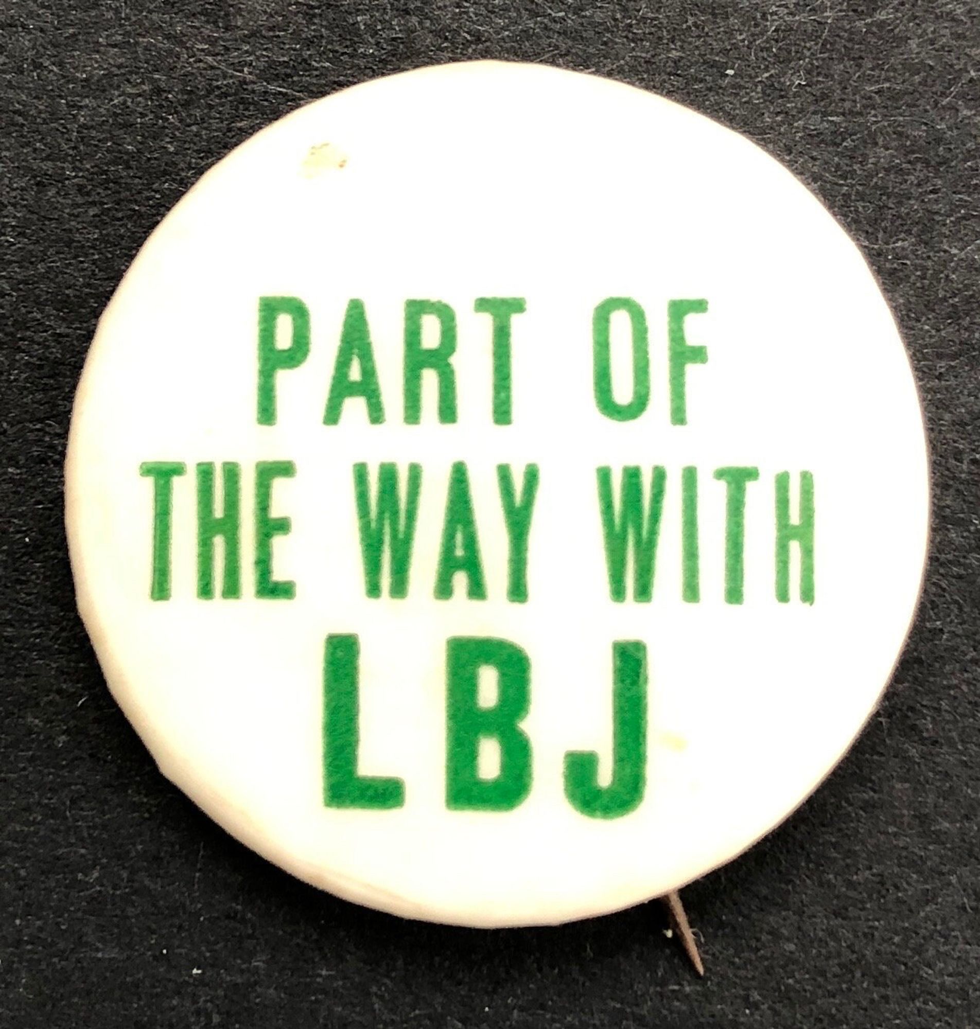 Vintage pinback button with green text on a white background reads “Part of the way with LBJ”